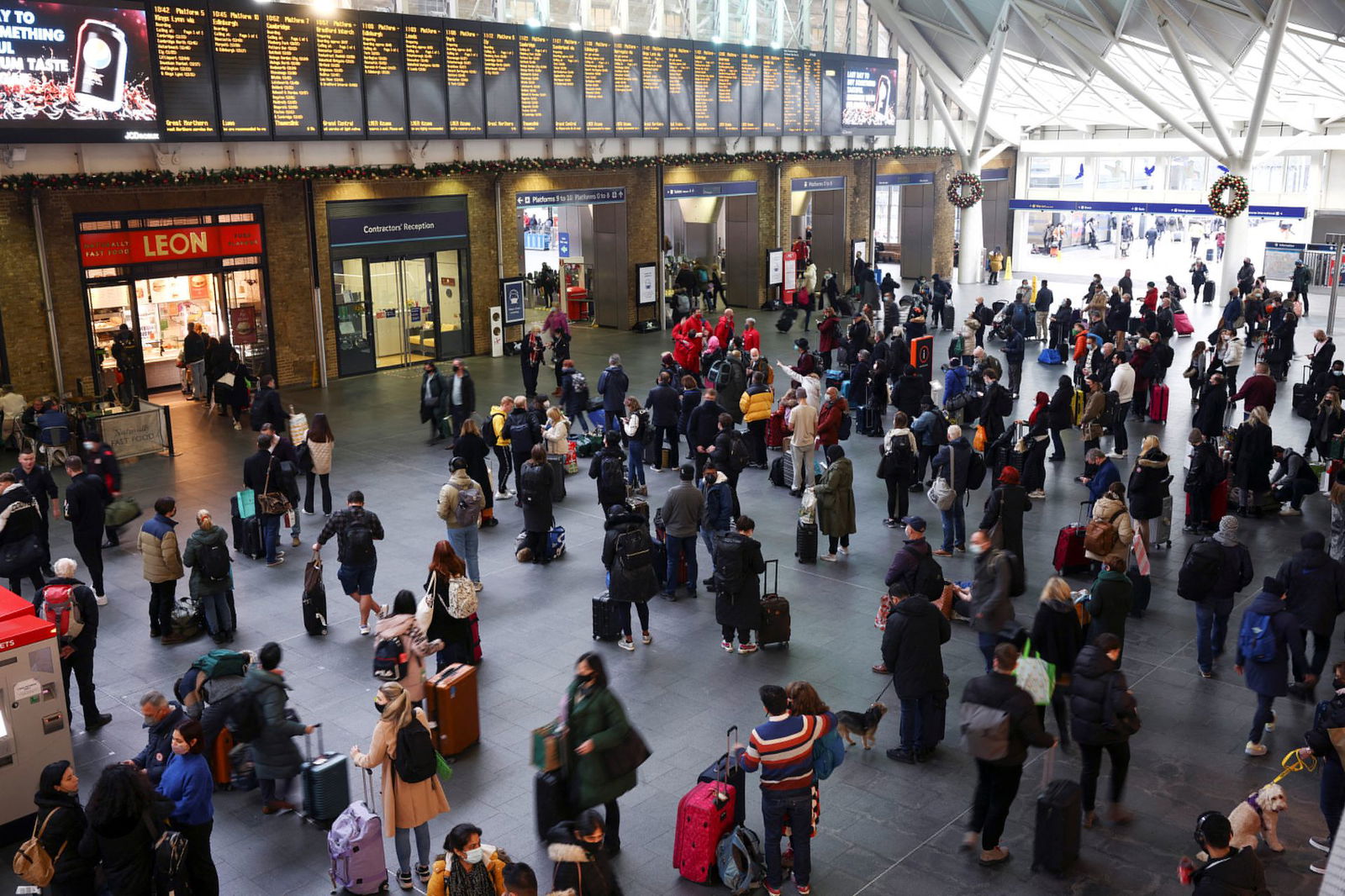 People stand inside Kings Cross Station on Christmas Eve, amid the coronavirus disease outbreak in London, Britain, Dec. 24, 2021.