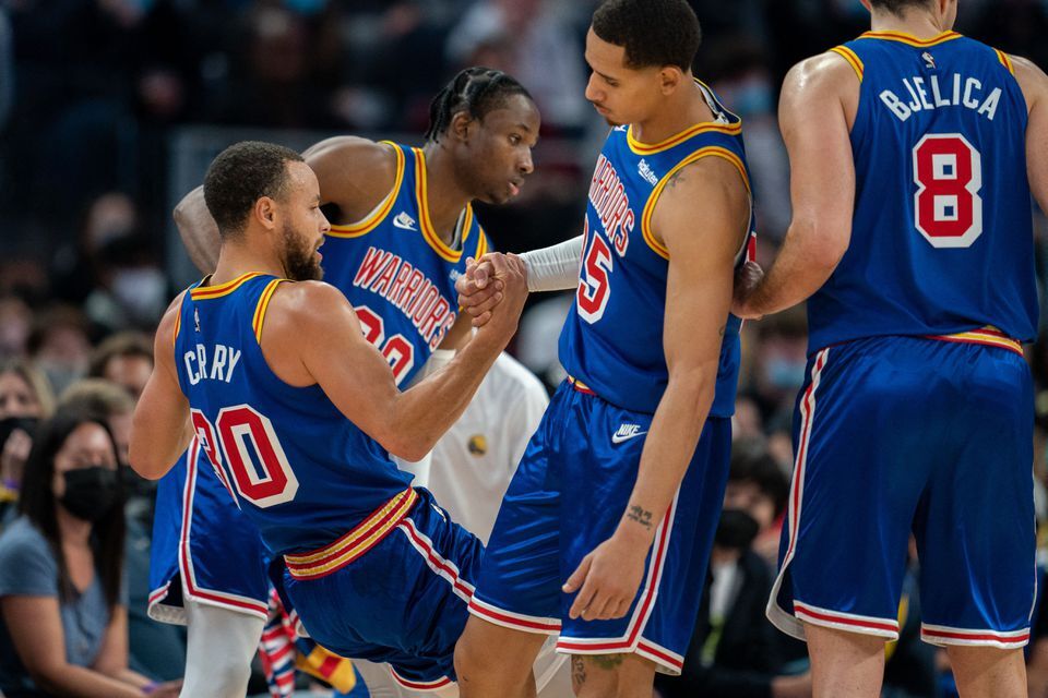 Golden State Warriors forwards Juan Toscano-Anderson (95) and Jonathan Kuminga (00) assist guard Stephen Curry (30) off the floor during the third quarter against the Memphis Grizzlies at Chase Center in San Francisco, California on Dec. 23, 2021.
