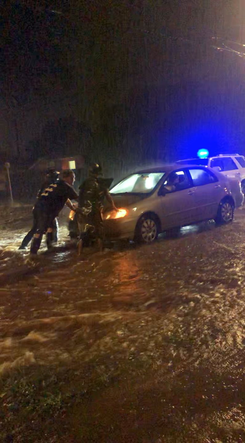 In this Dec. 6, 2021 still image taken from video provided on social media, people in Honolulu push a car along a flooded road, as Hawaii prepared for more rainfall on Tuesday after the Pacific island chain was beset with torrential downpours that caused flooding, triggered landslide warnings and prompted the state to take emergency action.