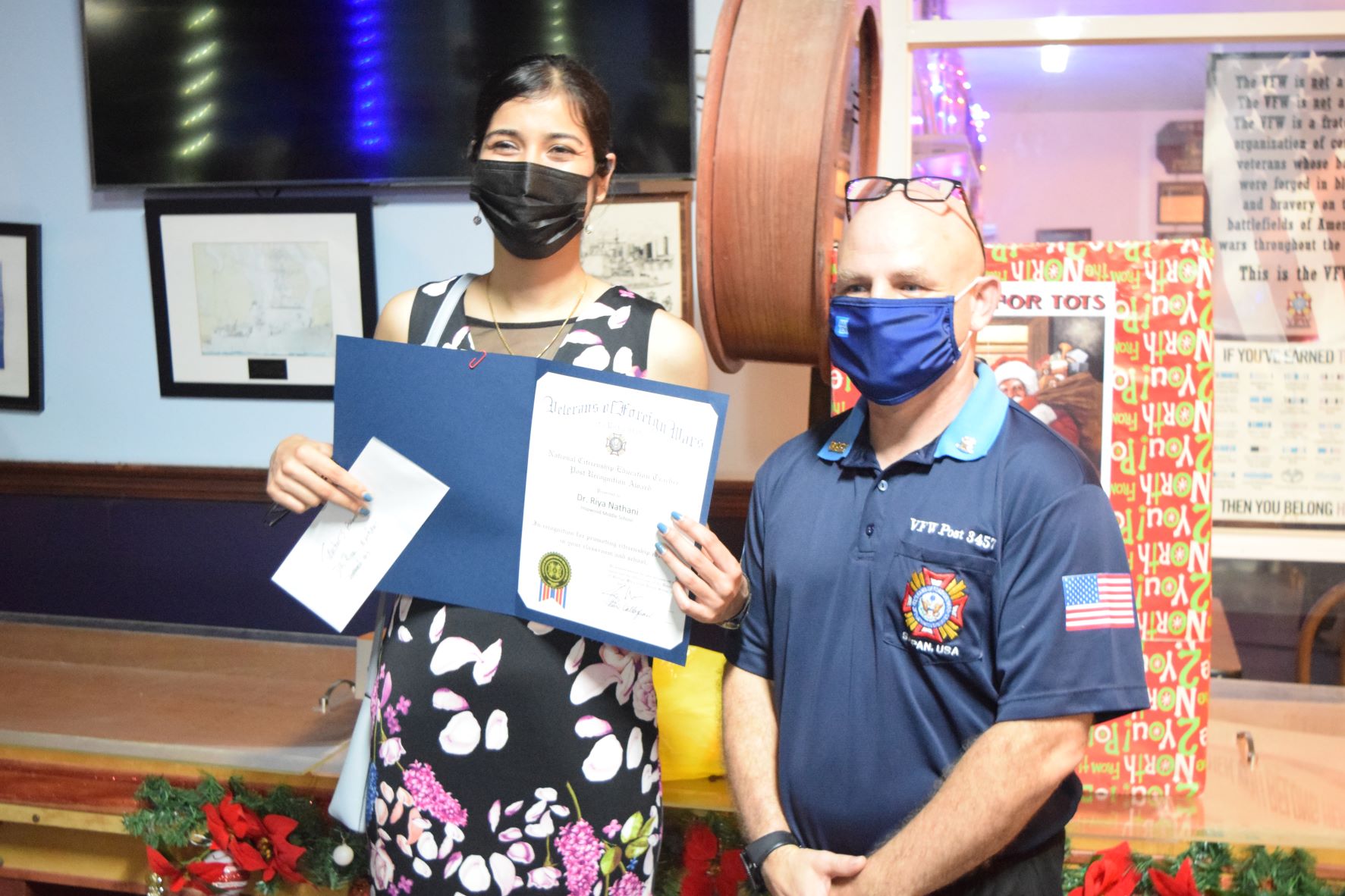 Hopwood Middle School teacher Dr. Riya Nathrani receives the National Citizenship Education Teacher Post Recognition Award from Veterans of Foreign Wars 3457 Post Commander Capt. Joey McDoulett at the VFW Post 345 in Garapan on Friday.