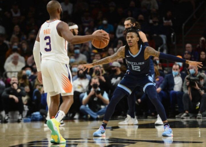 Memphis Grizzlies guard Ja Morant (12) defends Phoenix Suns guard Chris Paul (3) during the first half at Footprint Center in Phoenix, Arizona on Dec. 27, 2021.