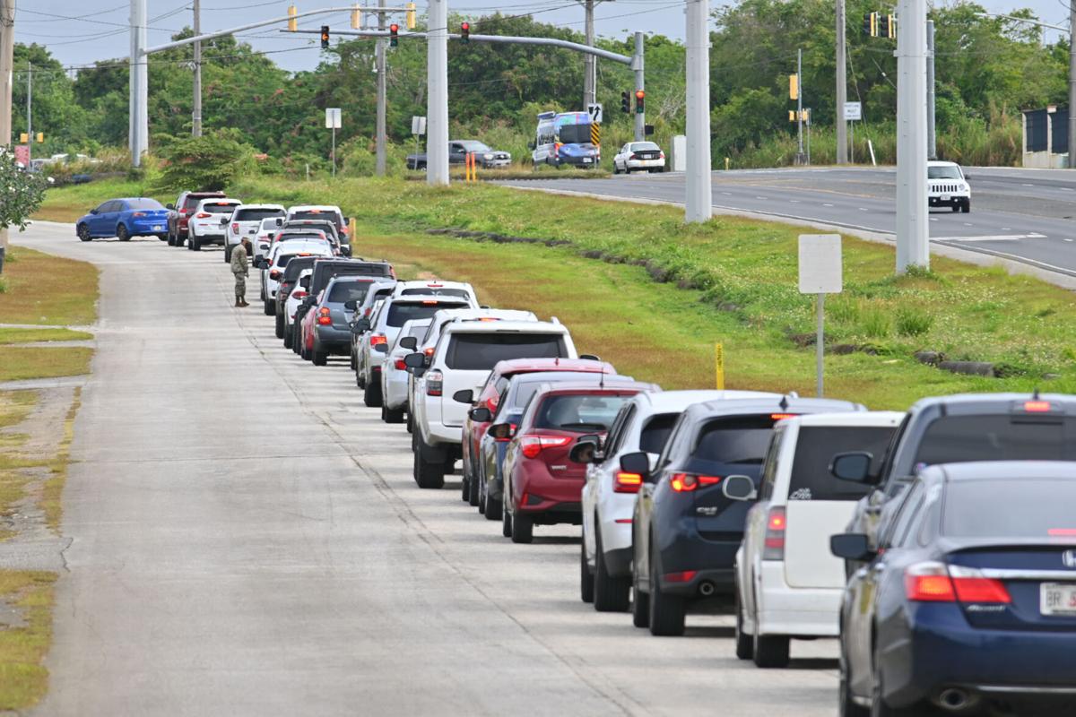 Motorists form a long line as they wait at the drive thru Covid-19 testing site Monday in Tiyan, Guam.