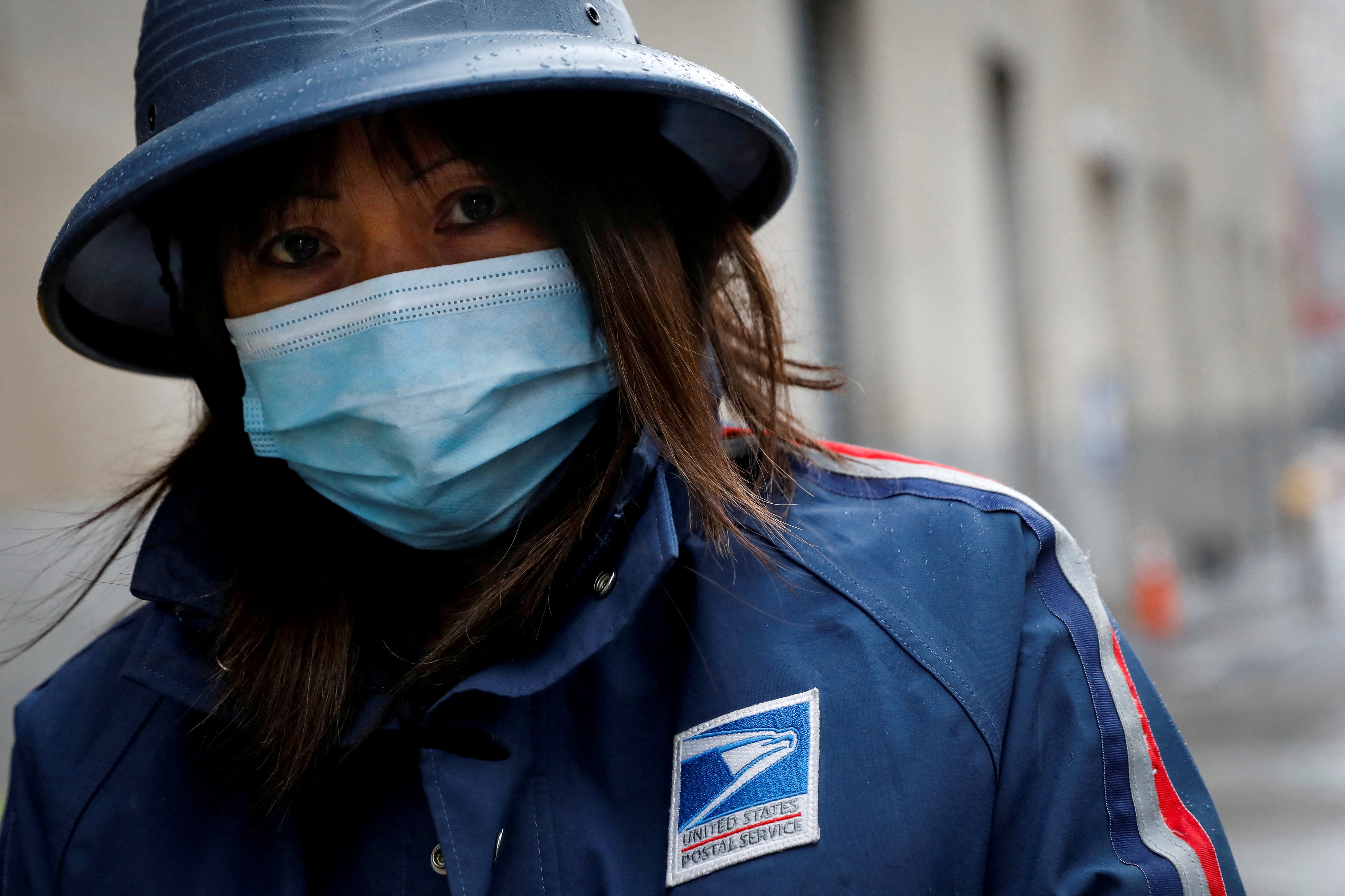A United States Postal Service employee works in the rain in Manhattan during the outbreak of the coronavirus disease in New York City on April 13, 2020.