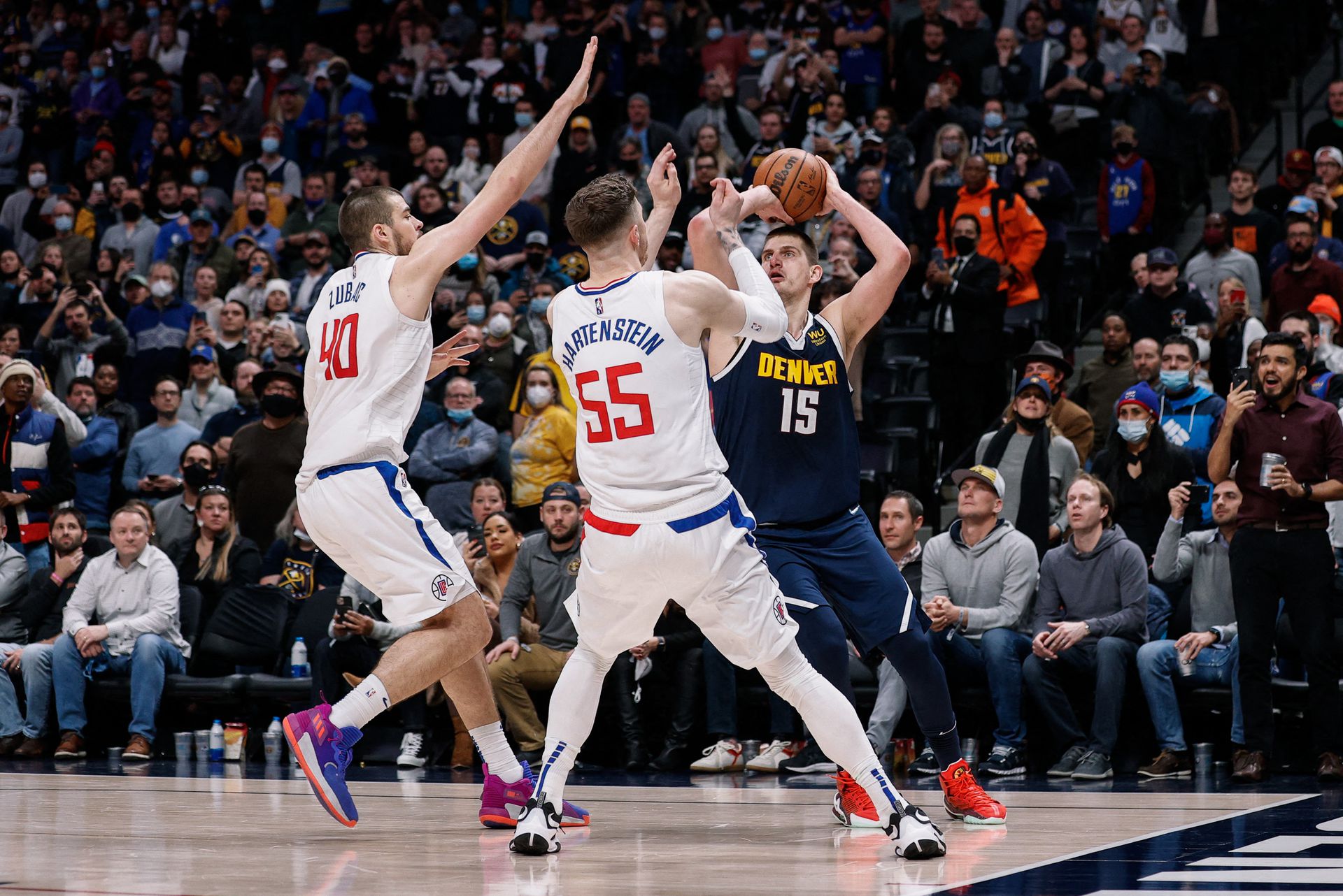 Denver Nuggets center Nikola Jokic (15) looks to the shoot the ball as Los Angeles Clippers center Isaiah Hartenstein (55) and center Ivica Zubac (40) defend in the fourth quarter at Ball Arena in Denver, Colorado on Jan. 19, 2022.