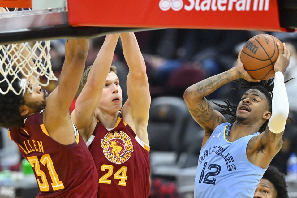 Memphis Grizzlies guard Ja Morant (12) drives to the basket beside Cleveland Cavaliers forward Lauri Markkanen (24) and center Jarrett Allen (31) in the third quarter at Rocket Mortgage FieldHouse in Cleveland, Ohio on Jan. 4, 2022.