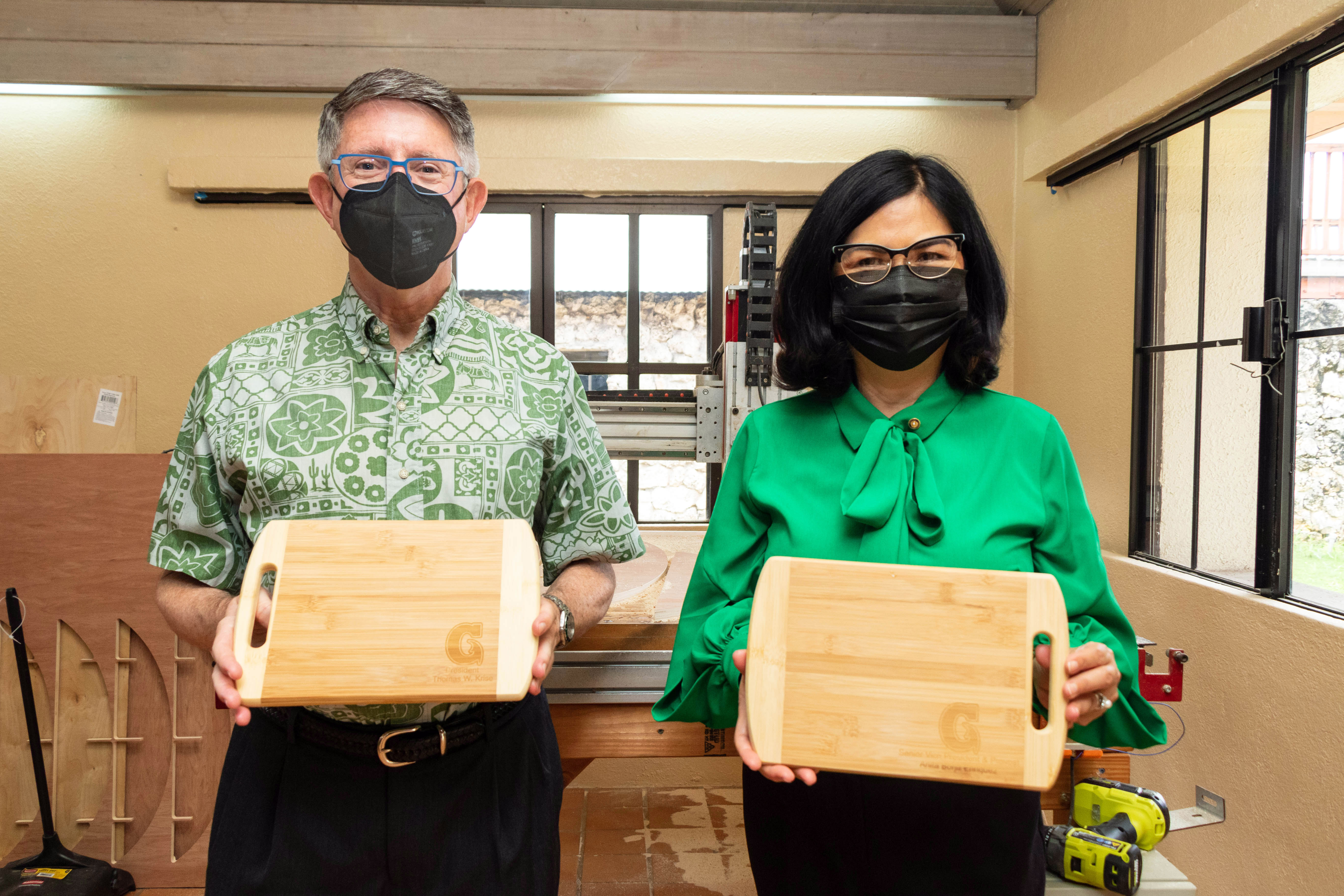 University of Guam President Thomas W. Krise and Senior Vice Provost Anita Borja Enriquez pose with cutting boards that were engraved using a laser cutter at the G3 Circular Economy Makerspace and Innovation Hub at CHamoru Village in Hagåtña.