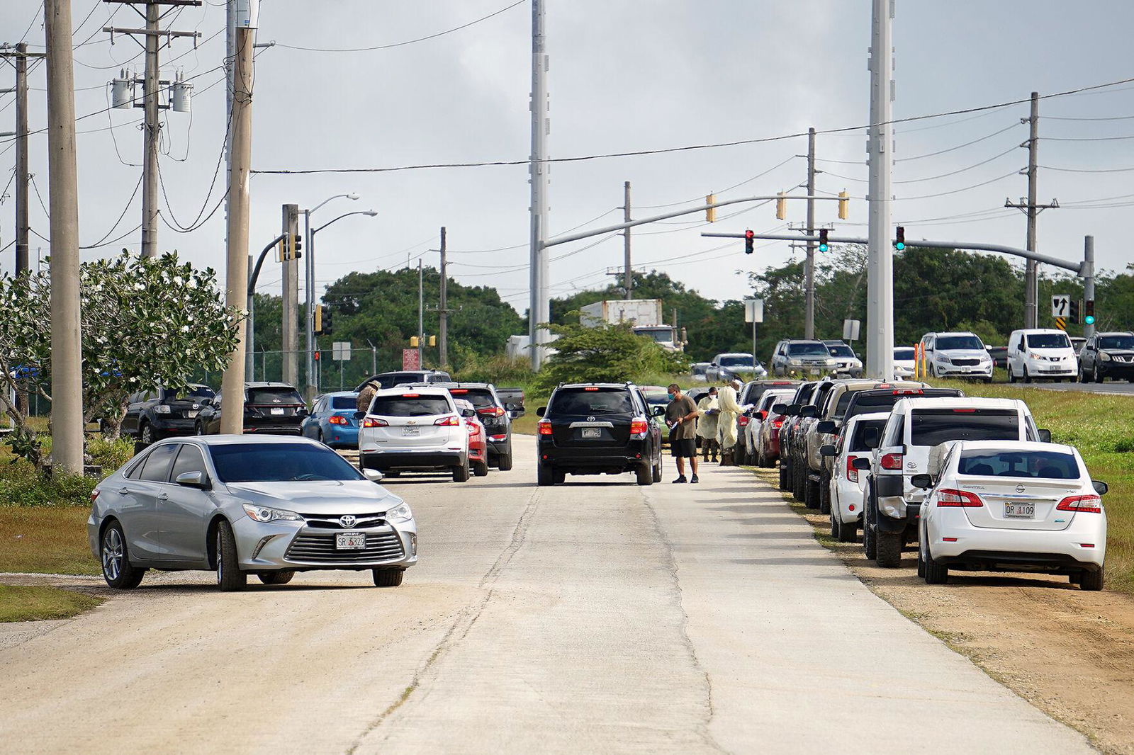 Vehicles were divided into two lines Tuesday morning along the old carnival grounds in Tiyan, Guam as drivers and passengers waited to be tested for Covid-19.