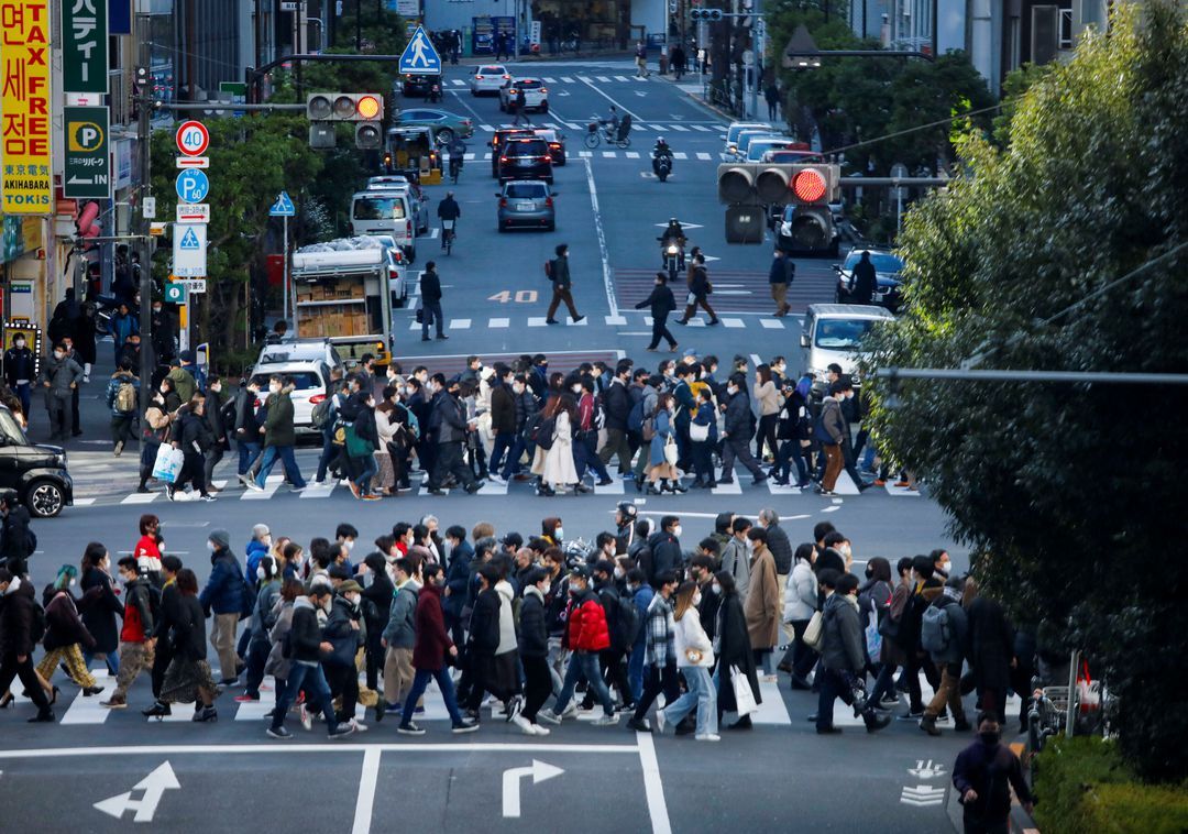 Passersby wearing protective face masks walk on the street in Tokyo, Japan, Jan. 15, 2022.