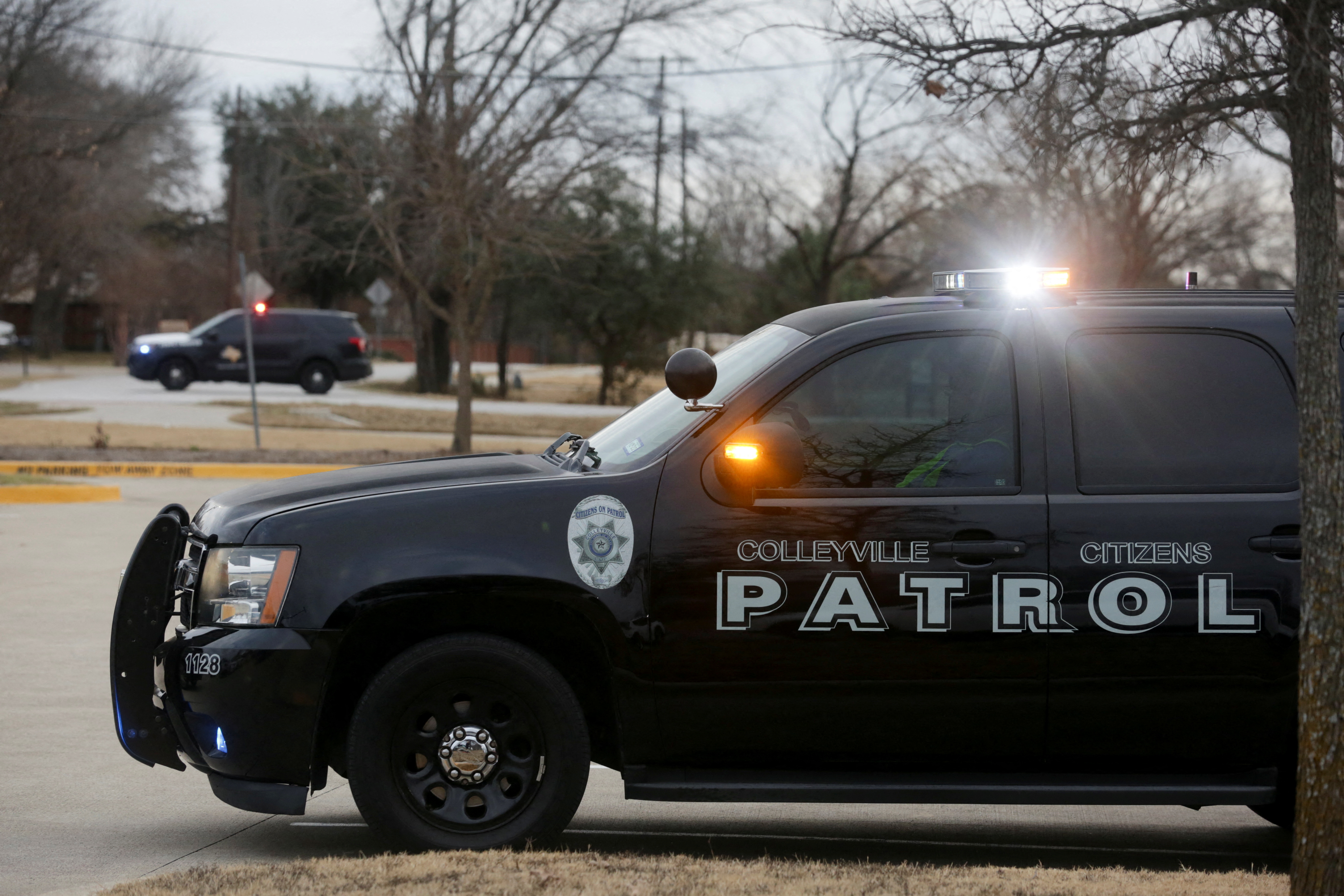 Law enforcement vehicles are seen in the area where a man has reportedly taken people hostage at a synagogue during services that were being streamed live, in Colleyville, Texas, Jan. 15, 2022.
