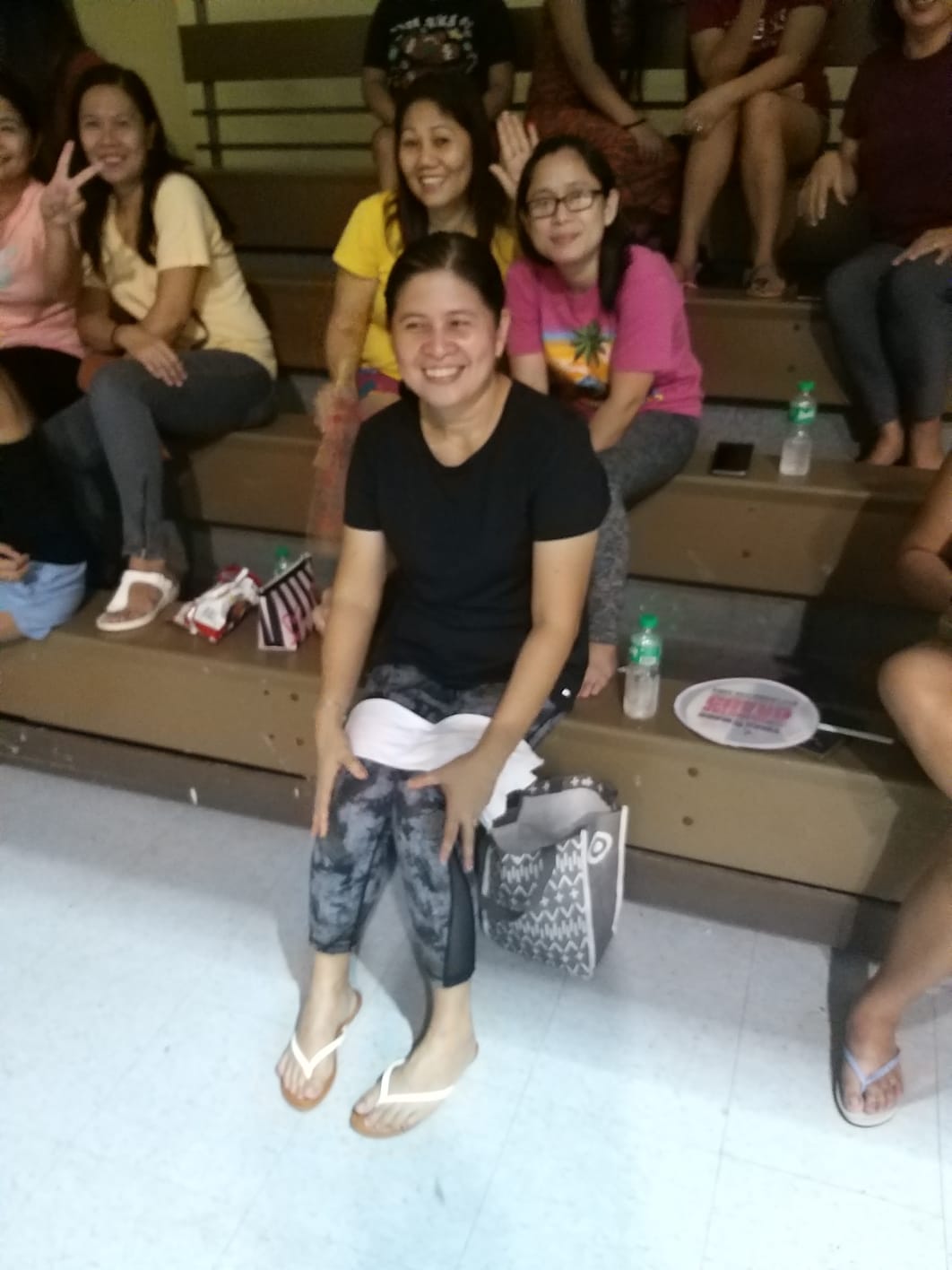 Inday Vergara, center foreground, smiles as she watches a game of the 2021 Tinian Islandwide Men's Bud Light Basketball League at the Tinian gymnasium.