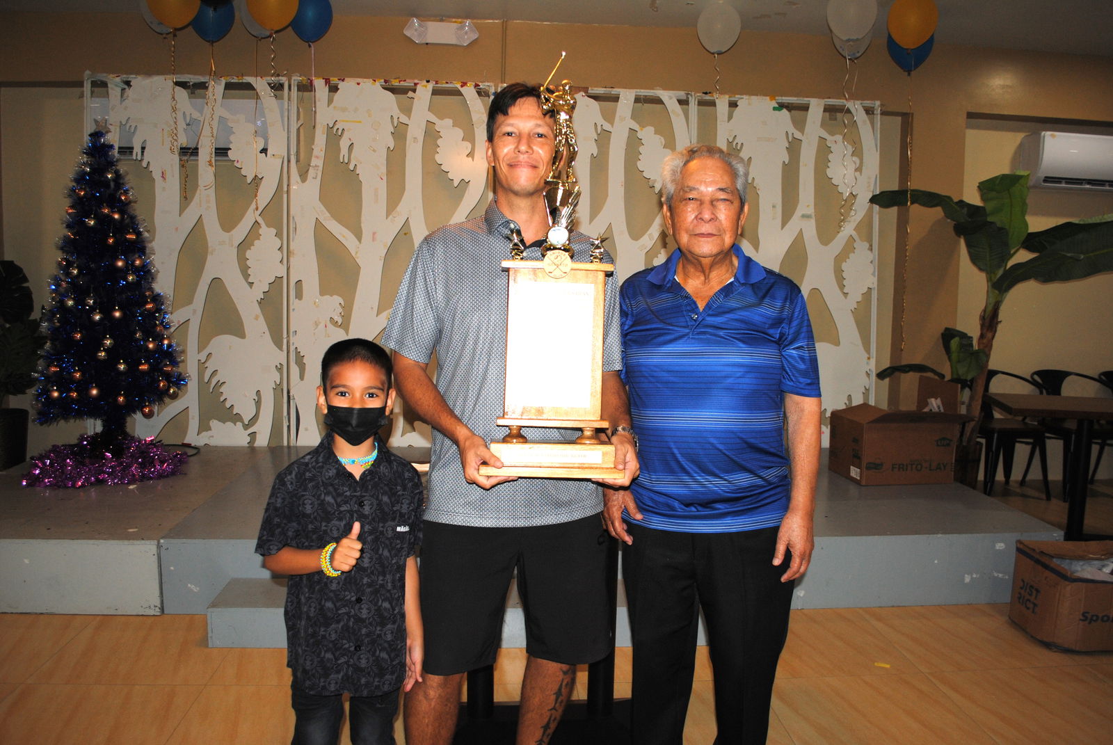 Dung Tenorio, center, holds the Ace of Aces trophy as he poses for a photo with his son, left, and Jose Sablan Sr. during Friday's awards banquet at the Rendezvous Restaurant.