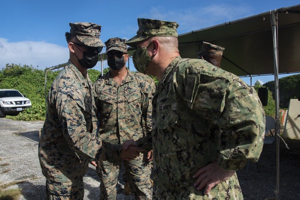 Joint Region Marianas Commander Rear Adm. Benjamin Nicholson greets Marines deployed to Tinian on Dec. 22, 2021.