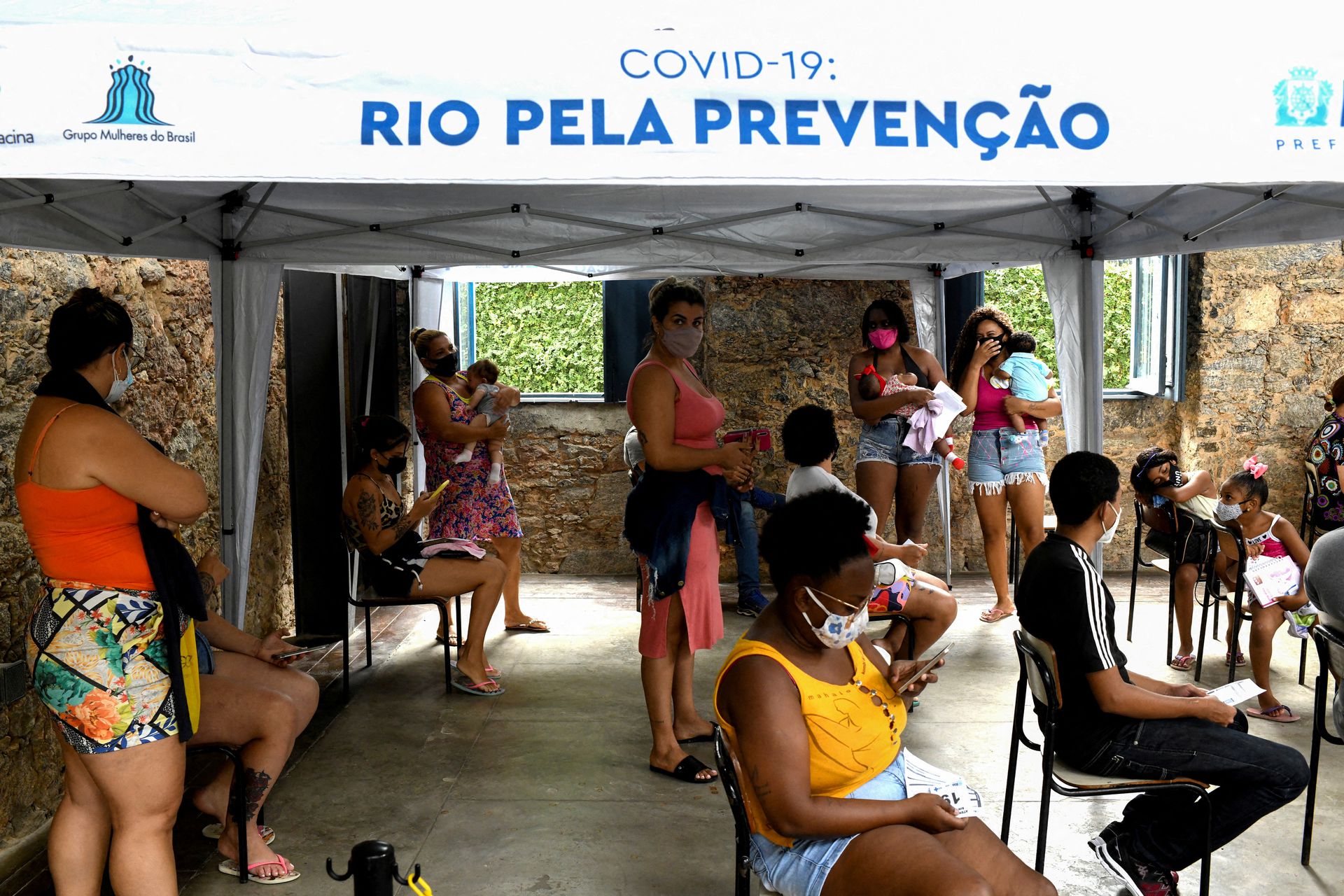 People wait to receive medical attention and to be tested for the coronavirus disease at Princess Isabel Palace where a healthcare unit specializing in Covid-19 and flu symptoms has been set up in Rio de Janeiro, Brazil, Jan. 12, 2022.