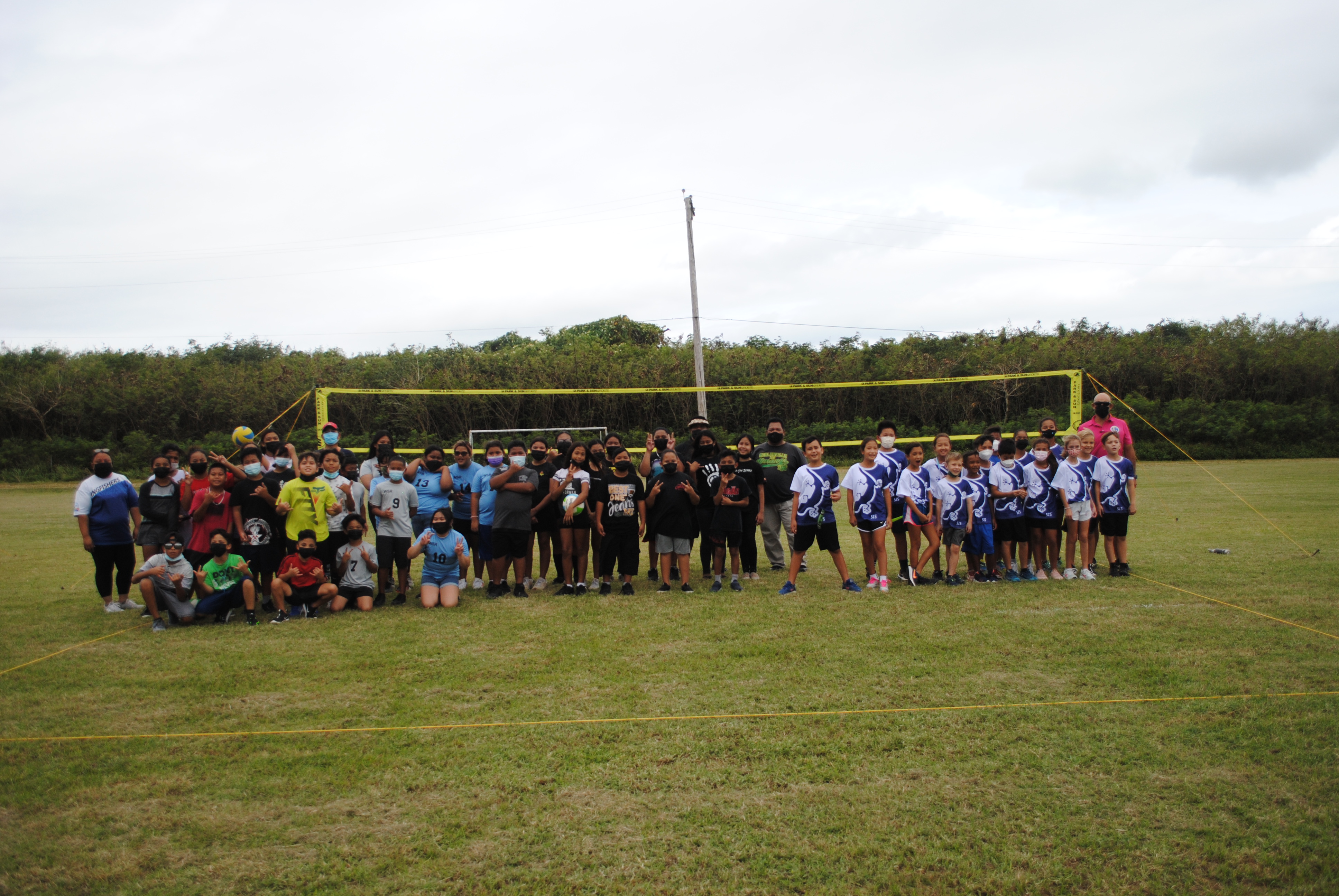 The participating  co-ed volleyball teams pose during a break from the games Saturday at the Chacha Oceanview Middle School field.