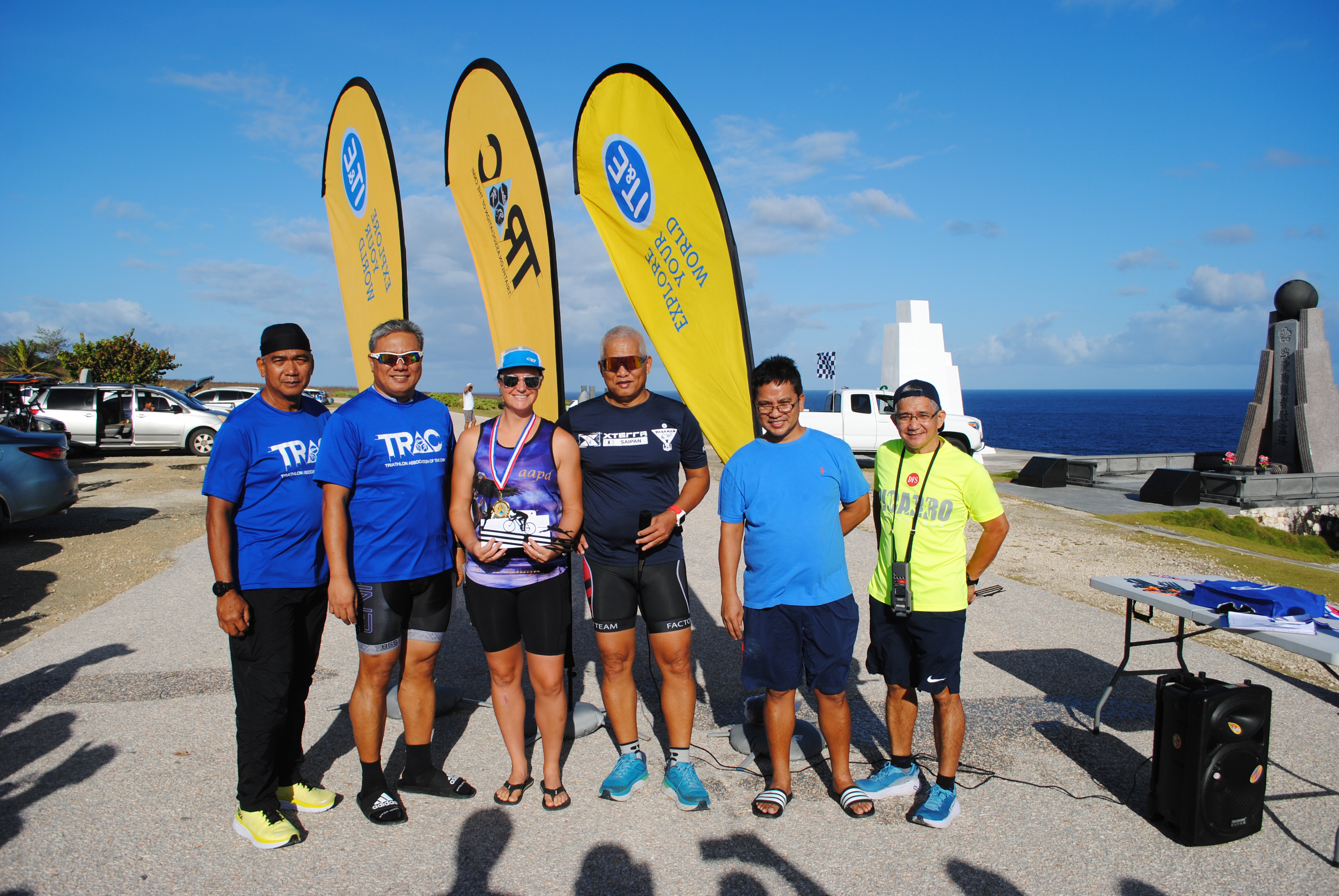 Kate Wilson, 3rd left, smiles as she holds the 1st place award while posing for a photo with officials of the Triathlon Association of the CNMI at the conclusion of the 6th Saipan Duathlon on Saturday at Banzai Cliff.