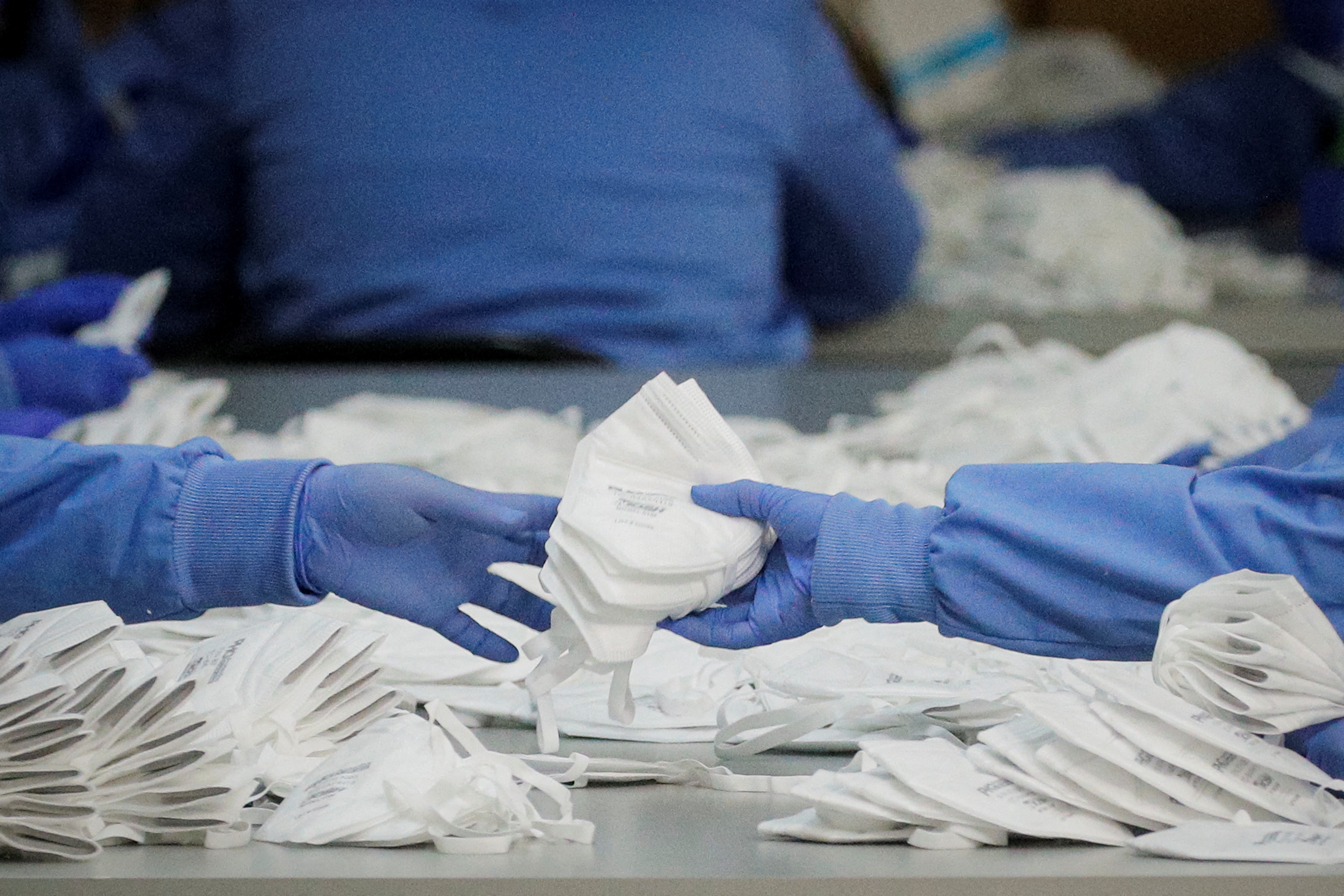Workers package N95 respirators at Protective Health Gear in Paterson, New Jersey, Jan. 14, 2022.