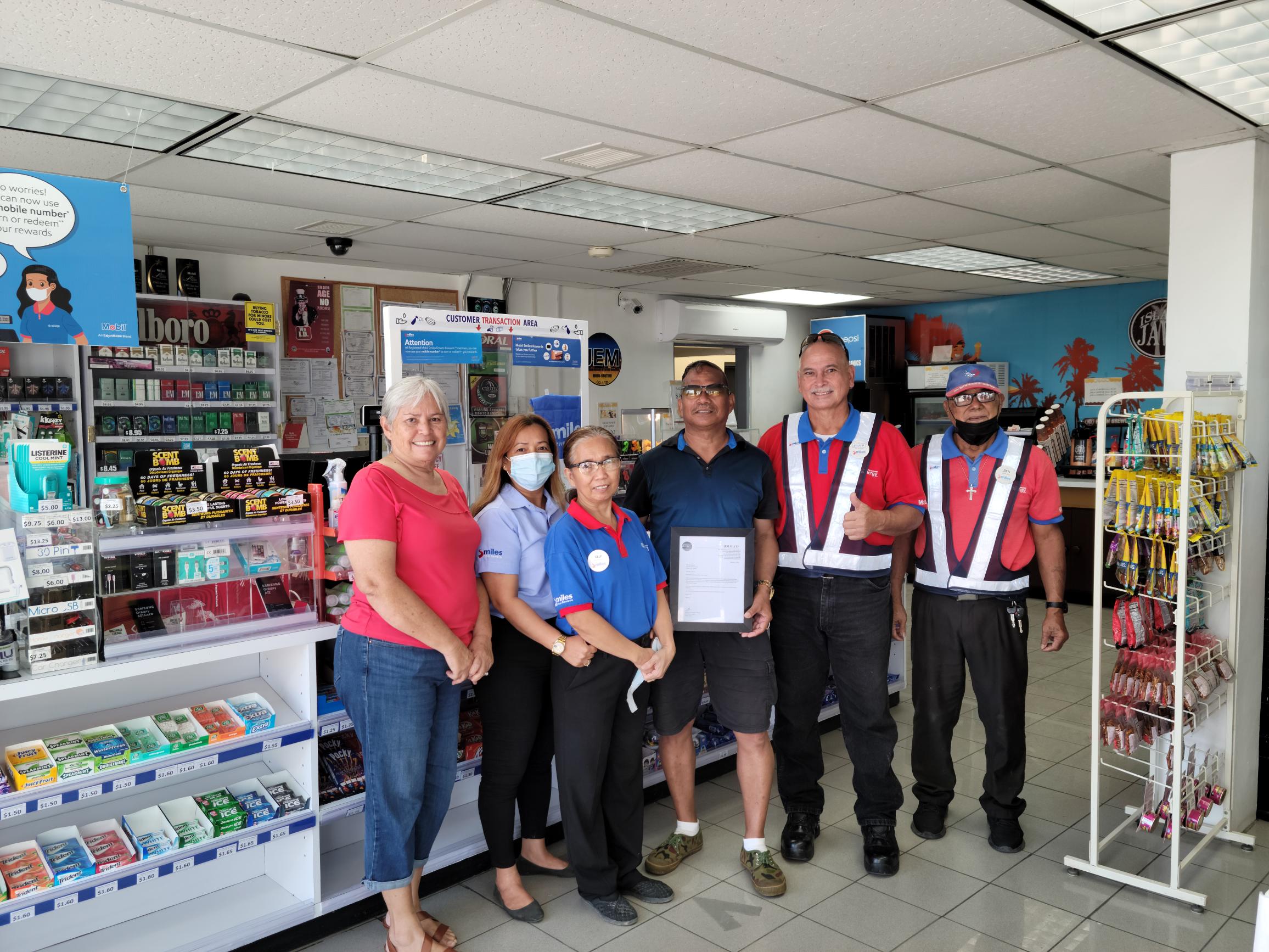 JEM Co. Ltd. operators Jovita Flores, left, and Edward Flores, 2nd right, have renewed the $100 monthly gas allowance of community volunteer Max Aguon, 4th from left, who regularly conducts islandwide cleanup activities. Also in photo are CMG San Jose Mobil store supervisor Emily Villagomez and staff.