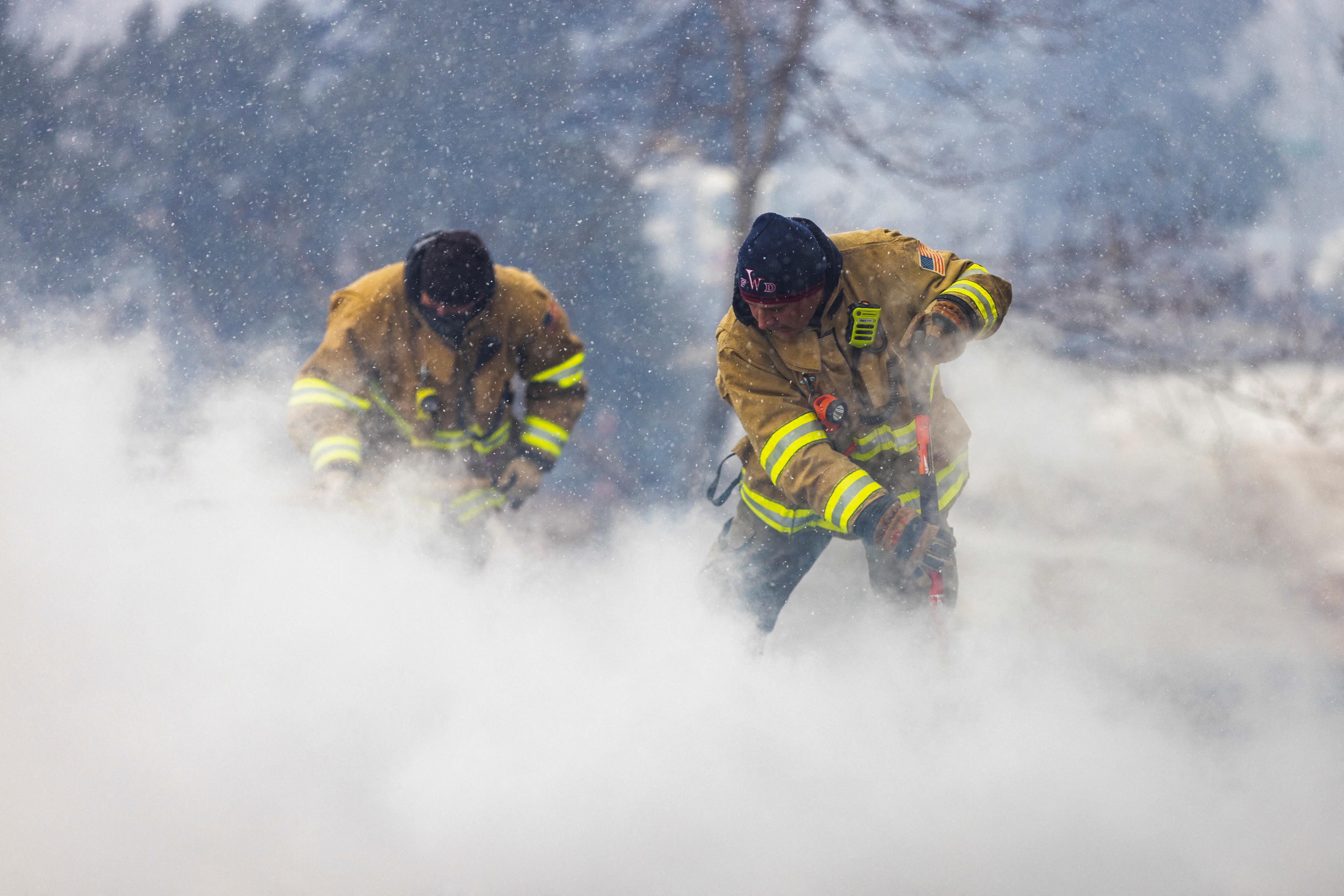 Westminster Fire Department members continue to put out flames from the Marshall Fire in Louisville, Colorado, Dec. 31, 2021.