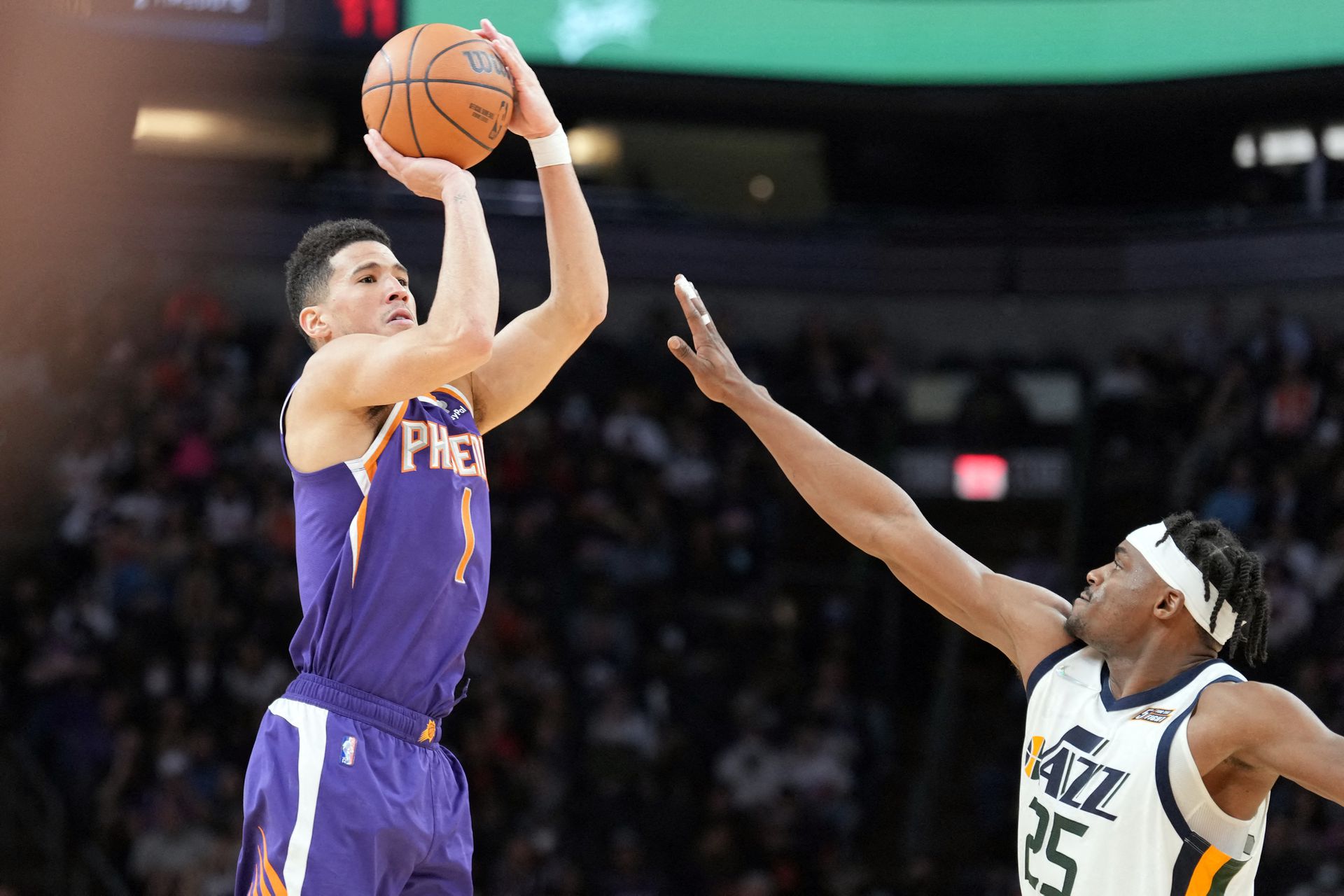 Phoenix Suns guard Devin Booker (1) shoots over Utah Jazz forward Danuel House Jr (25) during the second half at Footprint Center in Phoenix, Arizona, Jan. 24, 2022.