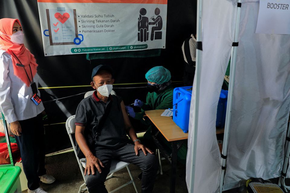 A man receives a booster dose of the Pfizer vaccine, as the country starts the booster vaccination program for the general public amid the rise of the Omicron variant in Jakarta, Indonesia, Jan. 12, 2022.
