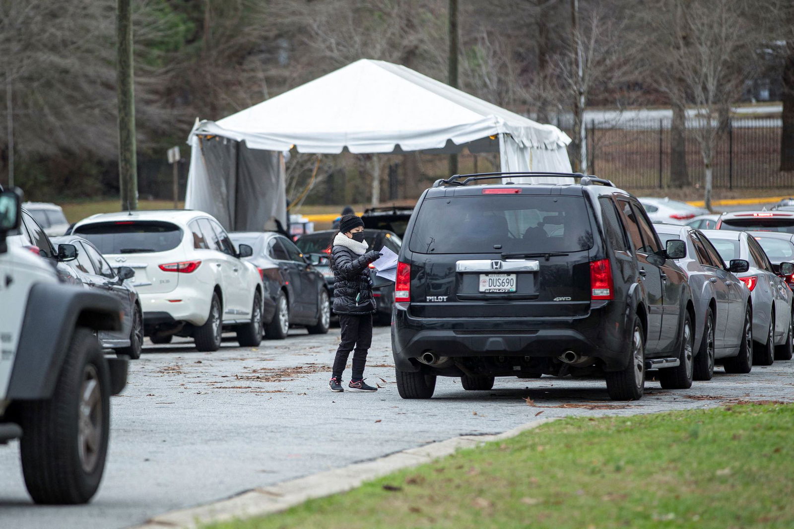 More than two dozen cars wait in line to take a Covid-19 test during a free drive-thru testing site in the parking lot of Frederick Douglass High School as students will go remote for a week to prevent the spread of coronavirus disease as cases of the Omicron variant continue to surge in Atlanta, Georgia, Jan. 3, 2022.