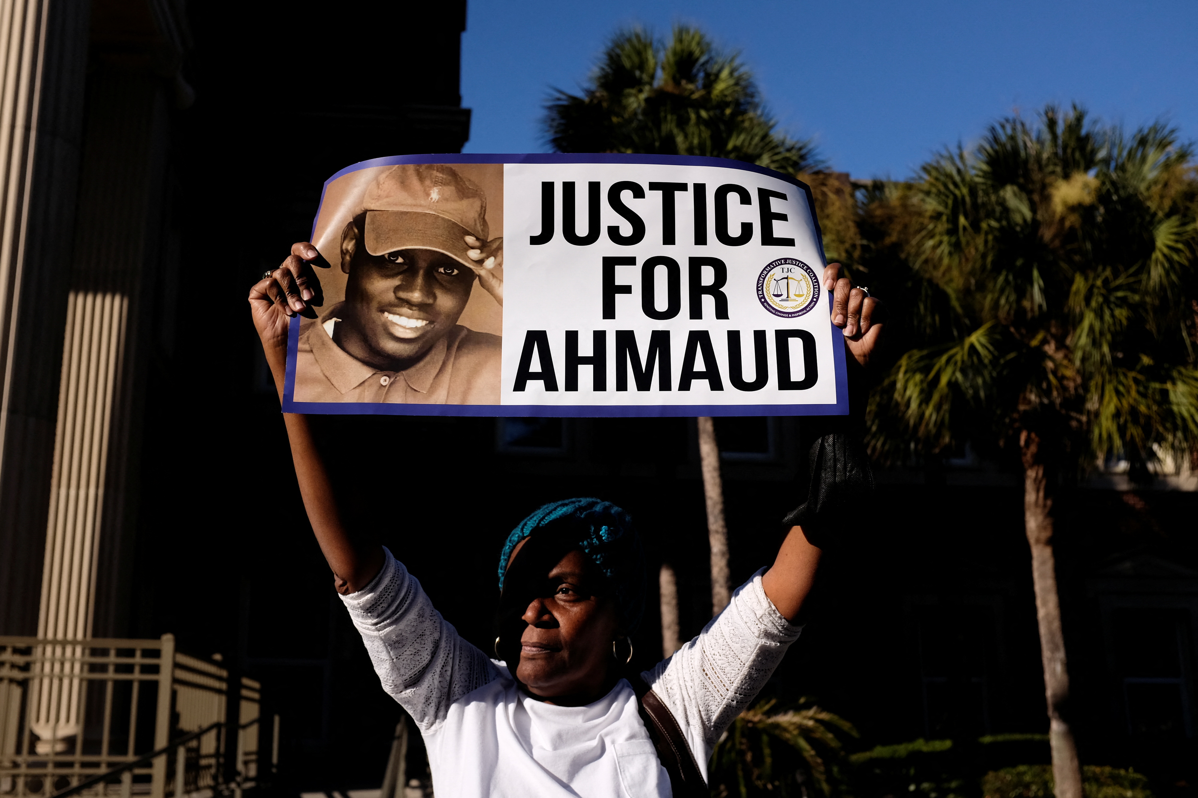 A woman holds a sign outside the Glynn County Courthouse after the jury reached a guilty verdict in the trial of William "Roddie" Bryan, Travis McMichael and Gregory McMichael, charged with the February 2020 death of 25-year-old Ahmaud Arbery, in Brunswick, Georgia, Nov. 24, 2021.