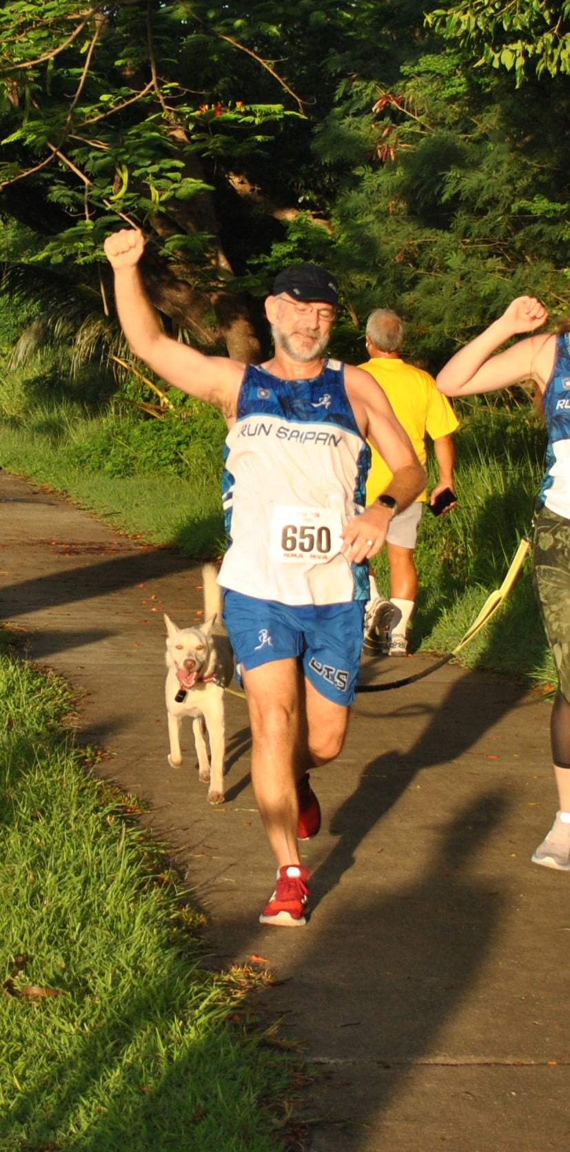 Dr. Ron Snyder celebrates as he crosses the finish line with his dog in the Run Saipan Underground 5K race  on July 10, 2021.