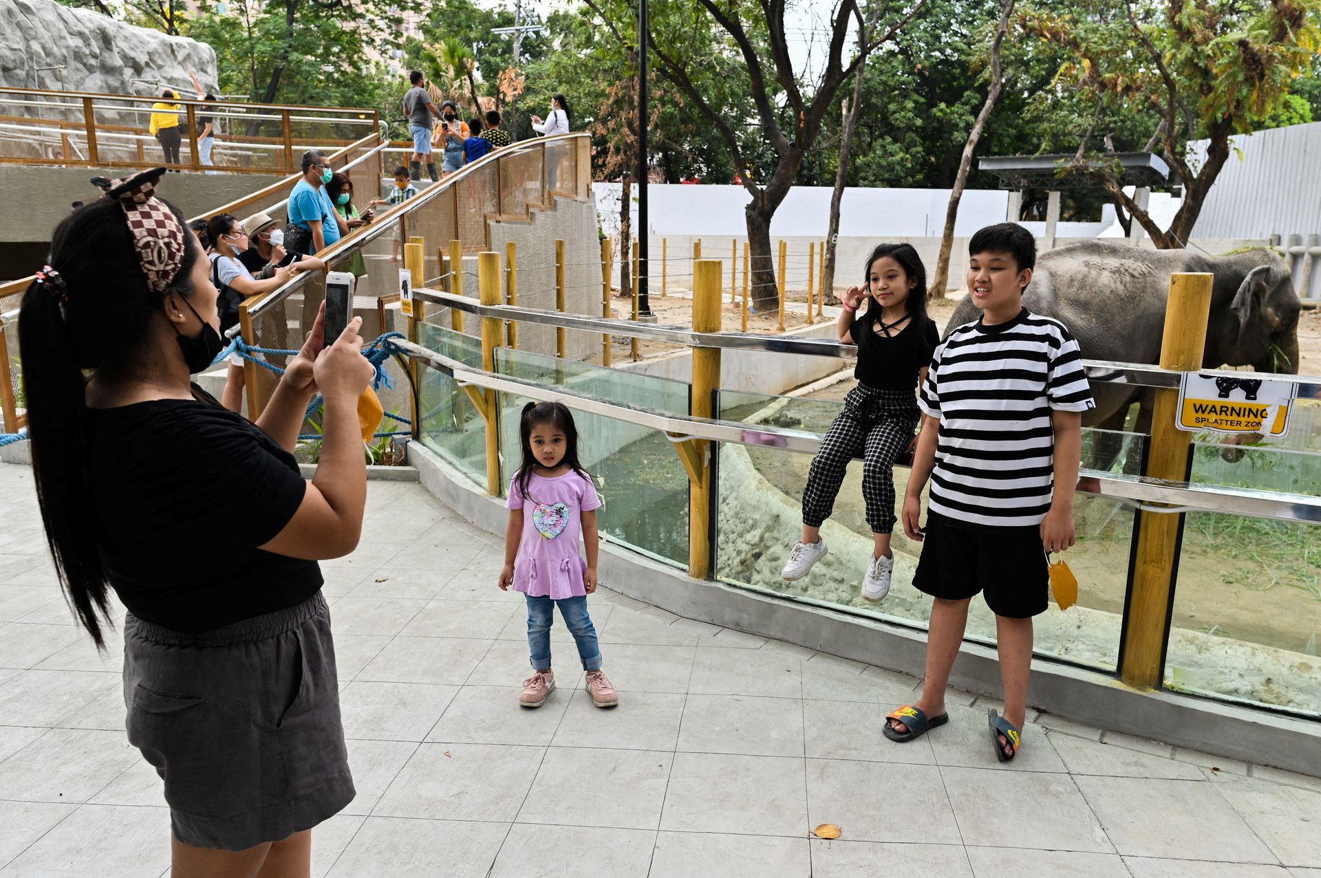 A woman takes picture with her phone as people visit Manila Zoo, which serves as a coronavirus disease vaccination site in the Philippine capital, Jan. 19, 2022.