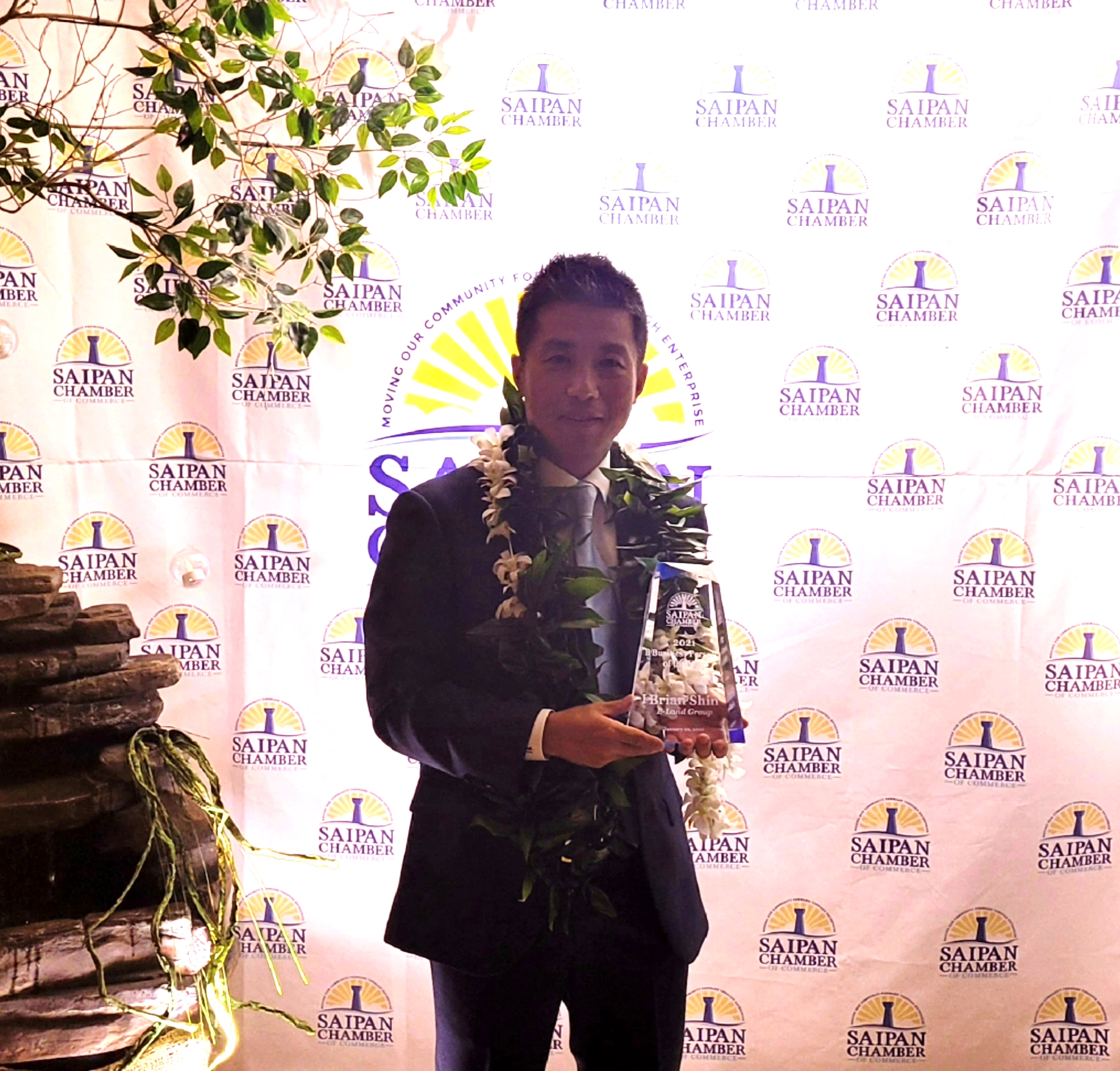 E-Land’s Brian Shin holds his Business Person of the Year trophy.