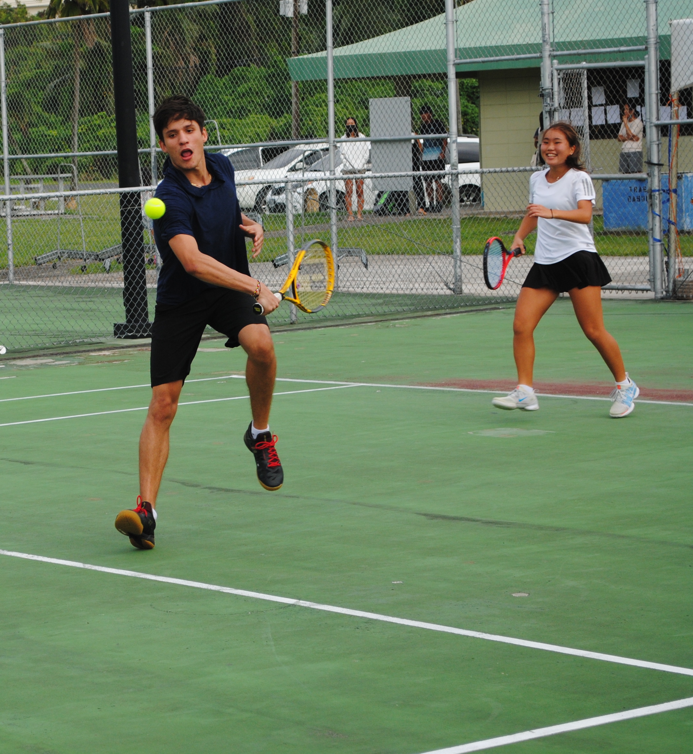 Matthew Berline reaches out for the save as teammate Serin Chung looks on during a semifinal match of the SIS Student Council Tennis Tournament on Saturday at American Memorial Park.