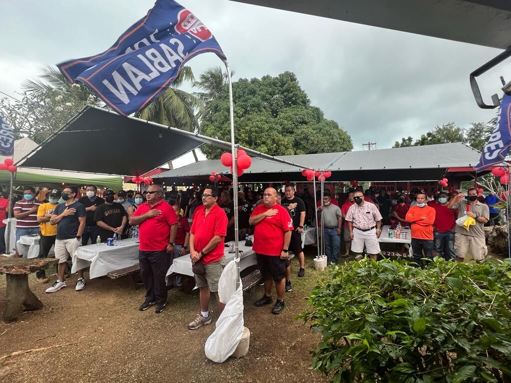 CNMI Republican Party supporters sing the national anthem at their newly opened campaign headquarters in Garapan on Saturday.