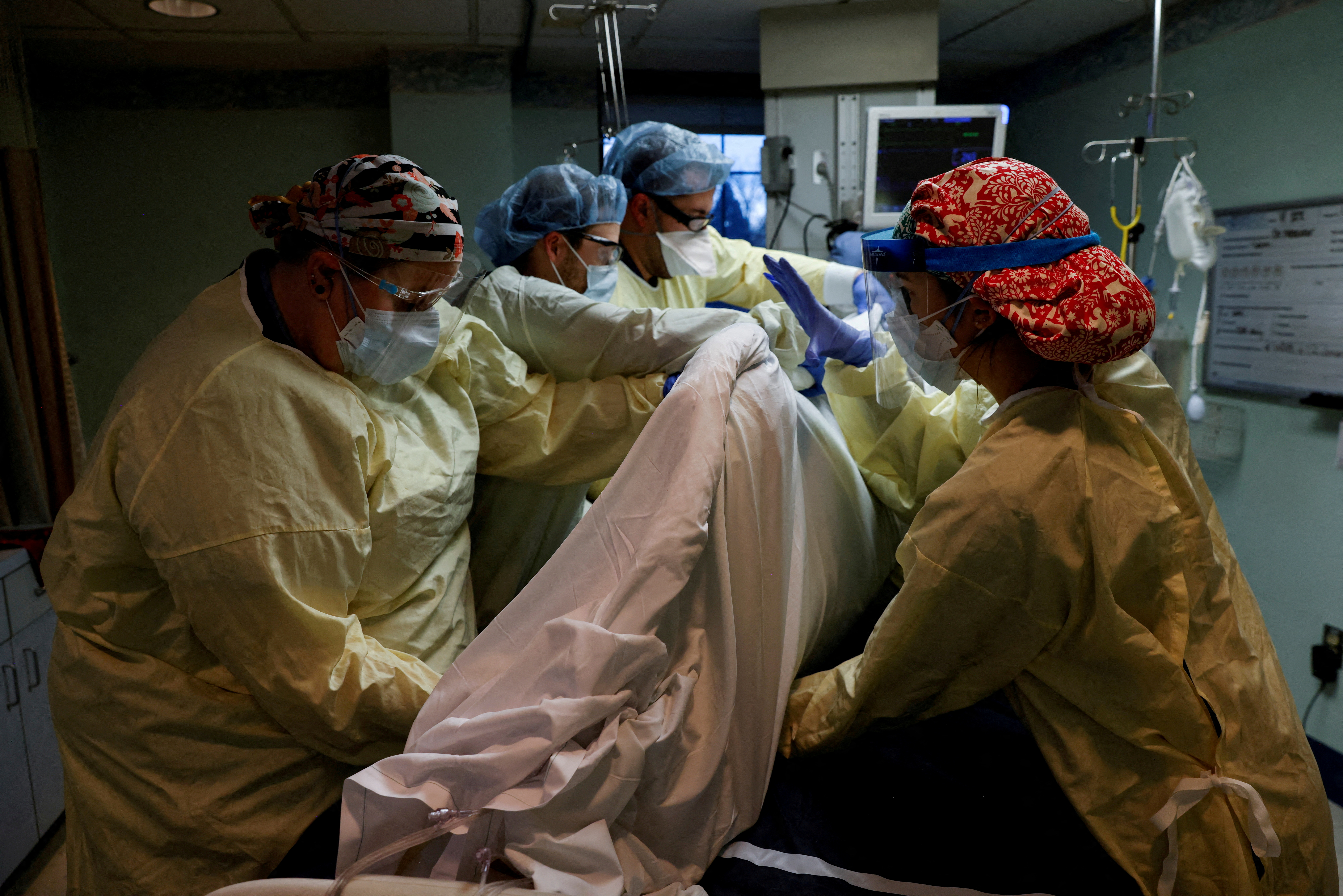 Medical staff treat a coronavirus disease patient in their isolation room at Western Reserve Hospital in Cuyahoga Falls, Ohio, Jan. 4, 2022.