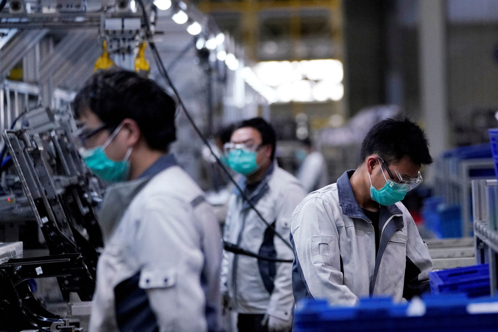 Employees wearing face masks work on a car seat assembly line at Yanfeng Adient factory in Shanghai, China, as the country is hit by an outbreak of a new coronavirus, Feb. 24, 2020.