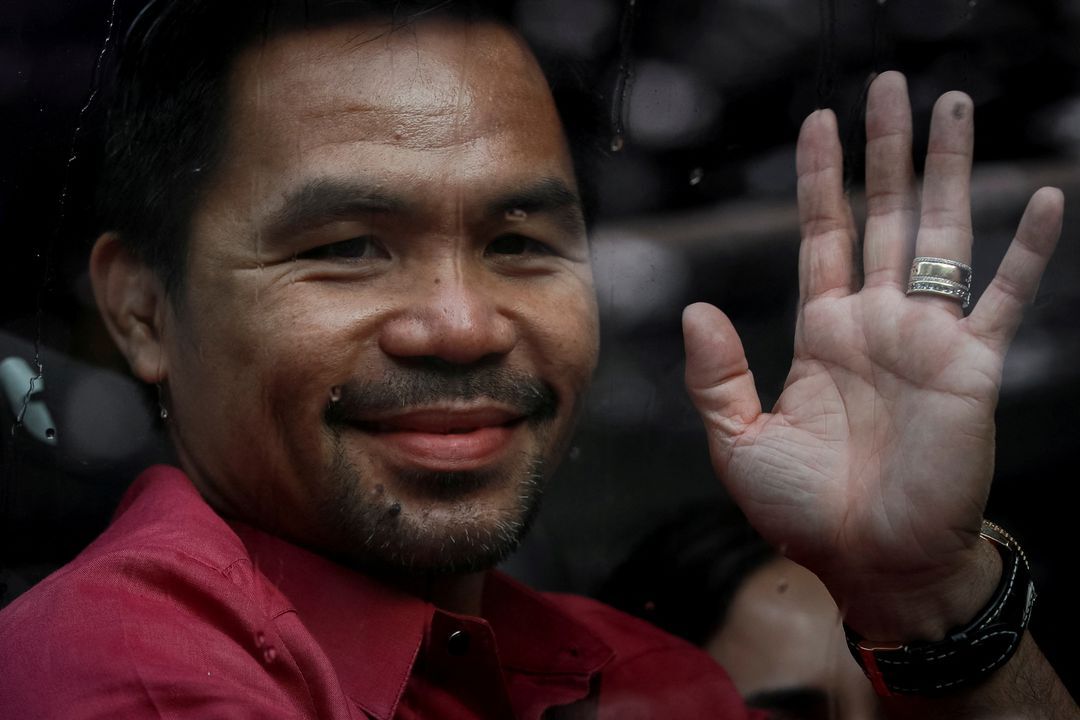 Philippine senator and newly retired boxing icon Manny Pacquiao waves to his supporters as he arrives at Sofitel Hotel to file his certificate of candidacy for president, in Pasay City, Metro Manila, Oct. 1, 2021.