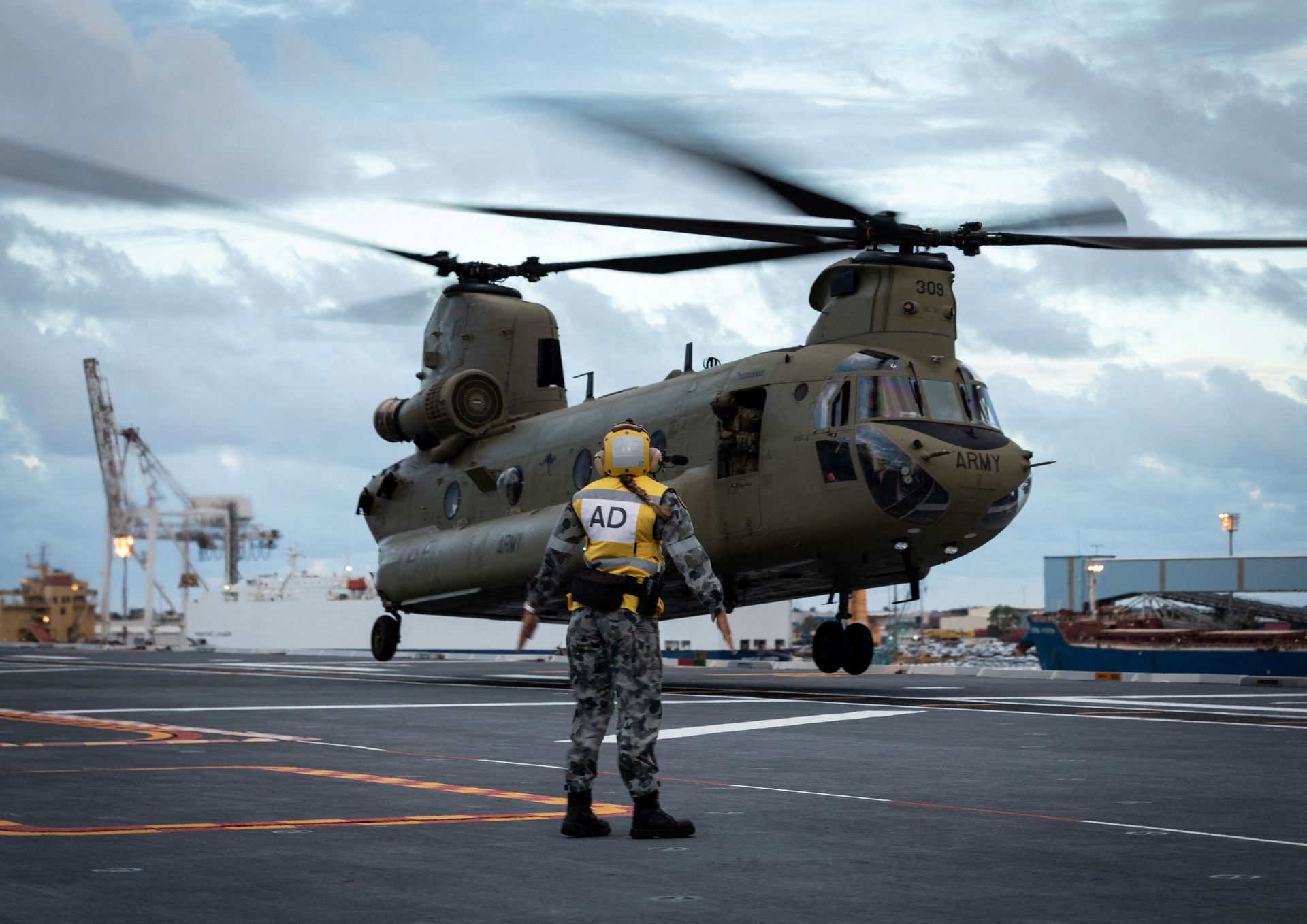 HMAS Adelaide embarks Australian Army CH-47 Chinook Heavy-Lift Helicopters before departing the port of Brisbane for Tonga to assist in relief efforts, Jan. 19, 2022.