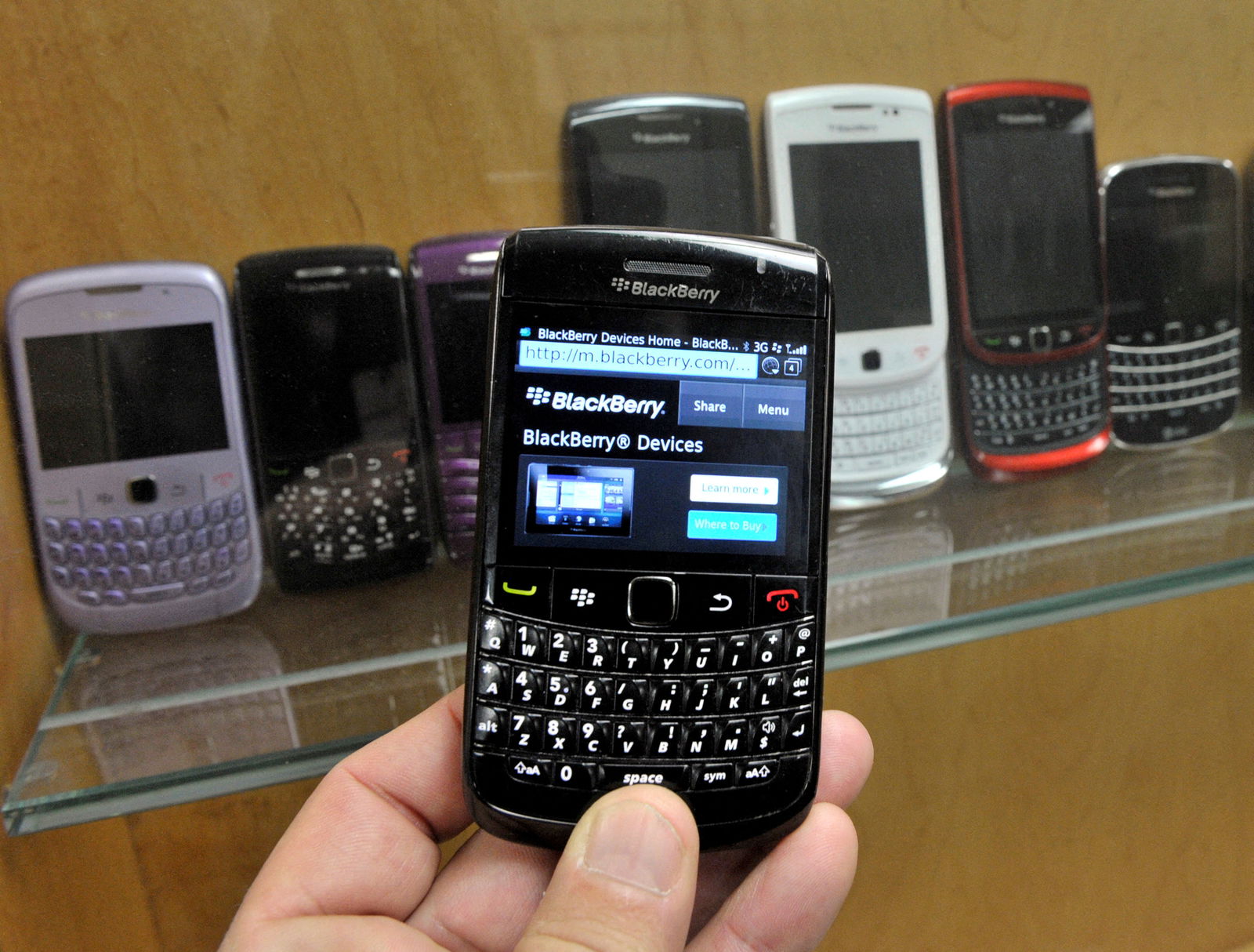 A BlackBerry device is shown in front of products displayed in a glass cabinet at the Research in Motion offices in Waterloo, Nov. 14, 2012.