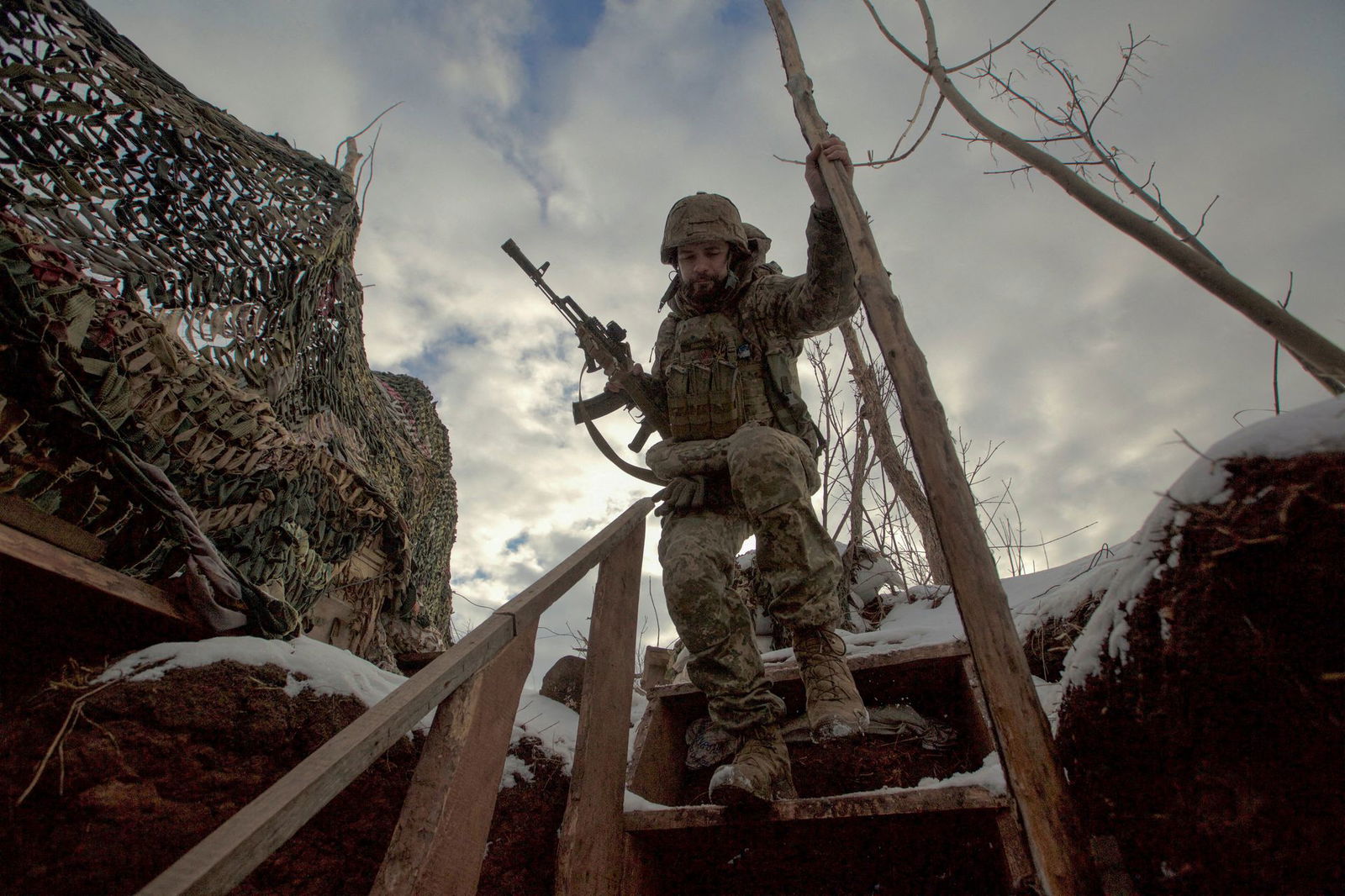 A service member of the Ukrainian armed forces walks at combat positions near the line of separation from Russian-backed rebels near Horlivka in the Donetsk region, Ukraine, Jan. 22, 2022.