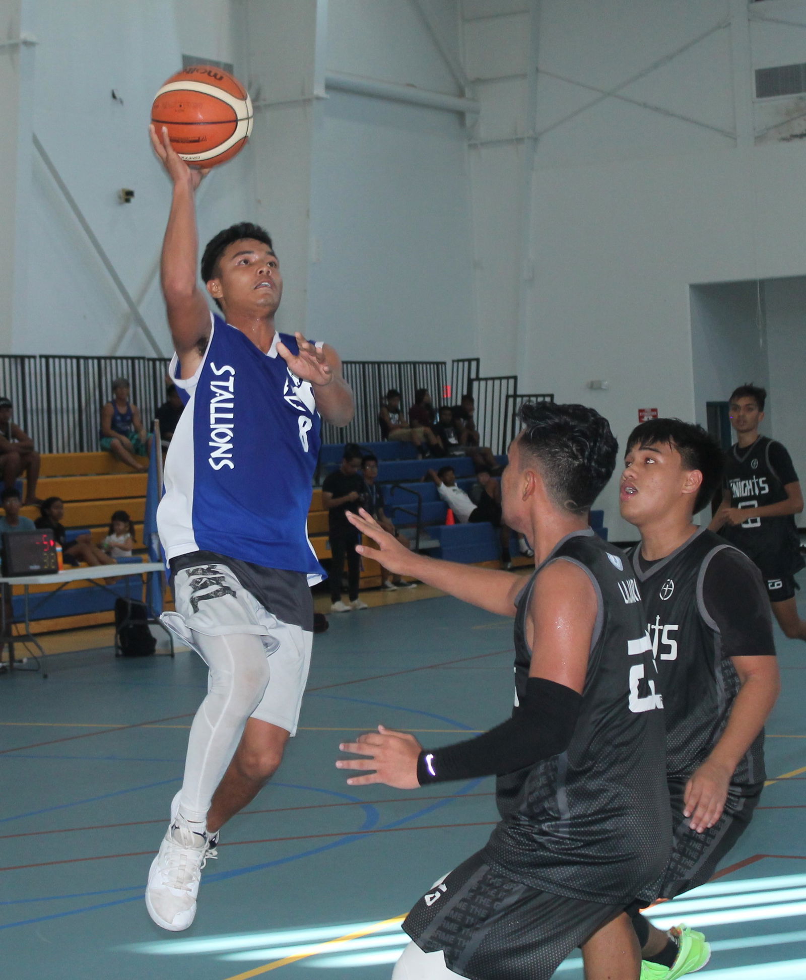 A Tinian player attempts a running shot over an MCS defender during the championship game of the 2019-2020 PSS boys high school basketball tournament at the MHS gym.
