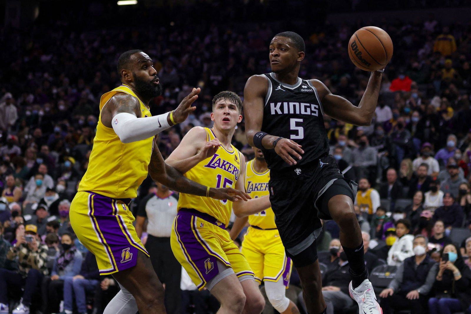 Sacramento Kings guard De'Aaron Fox (5) passes the ball against Los Angeles Lakers forward LeBron James (6) during the fourth quarter at Golden 1 Center in Sacramento, California on Jan. 12, 2022.