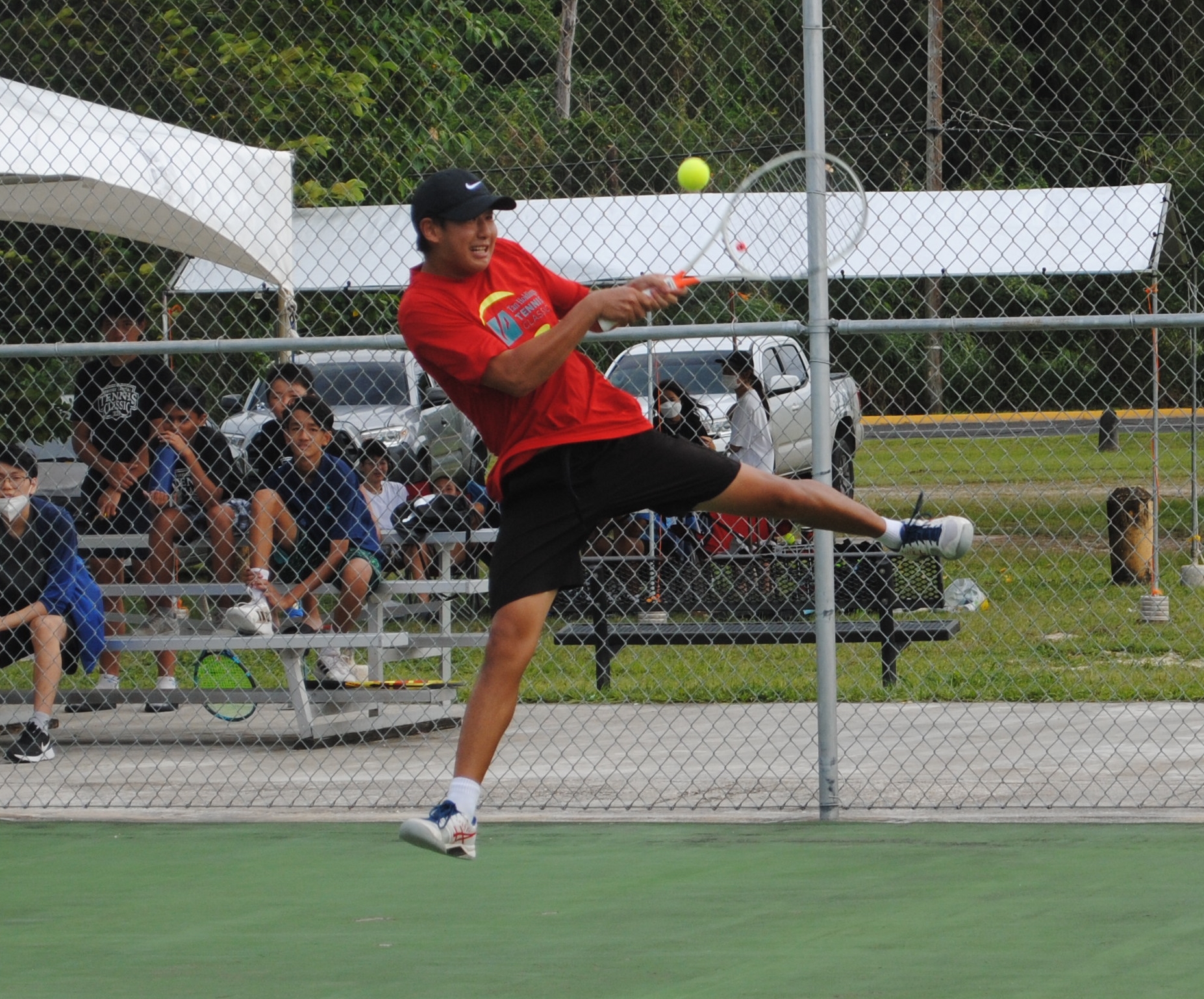 Sam Ryu leaps for the back hand return during a semifinal match of the SIS Student Council Tennis Tournament on Saturday at American Memorial Park.