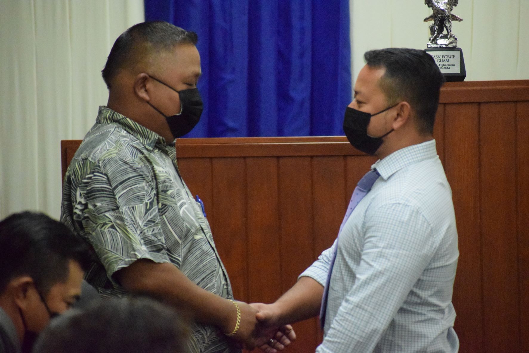 House Republican leader Angel Demapan and Rep. Joel Camacho, a Republican turned independent, shake hands.