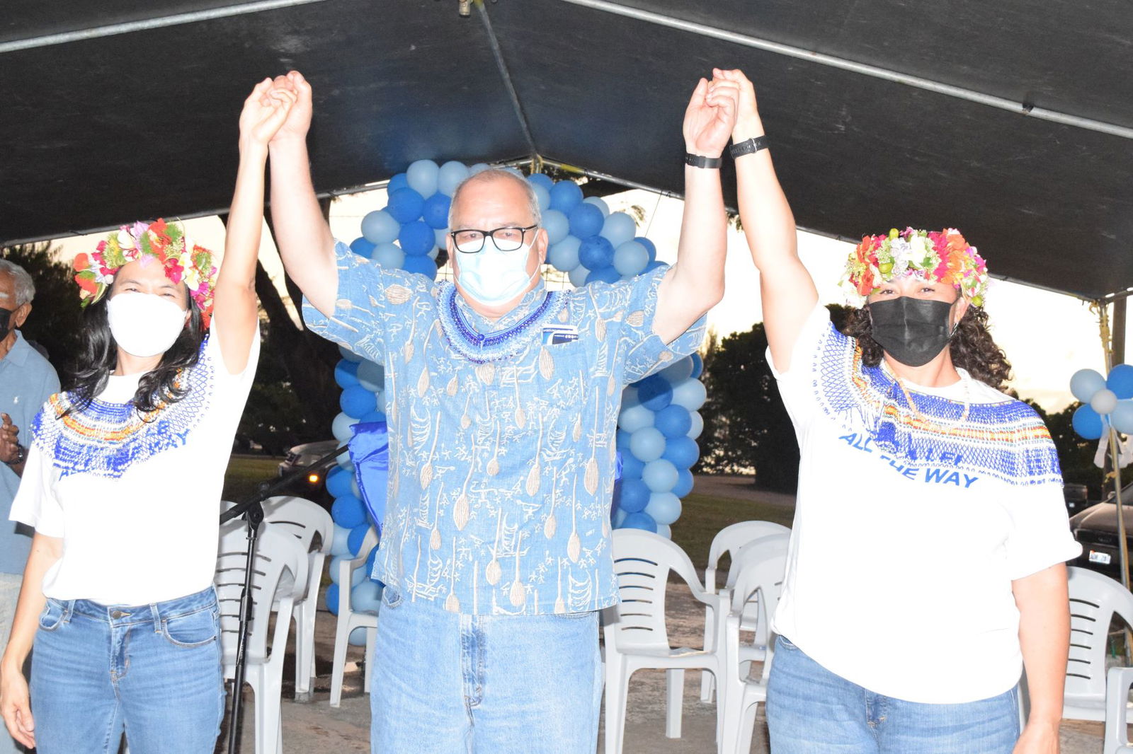 U.S. Congressman Gregorio Kilili Camacho Sablan, center, raises the hands of the NMI Democratic Party’s gubernatorial candidate, Rep. Tina Sablan, left, and her running mate, Rep. Leila Fleming Staffler, during a kick-off rally at Garapan Fishing Base on Wednesday.