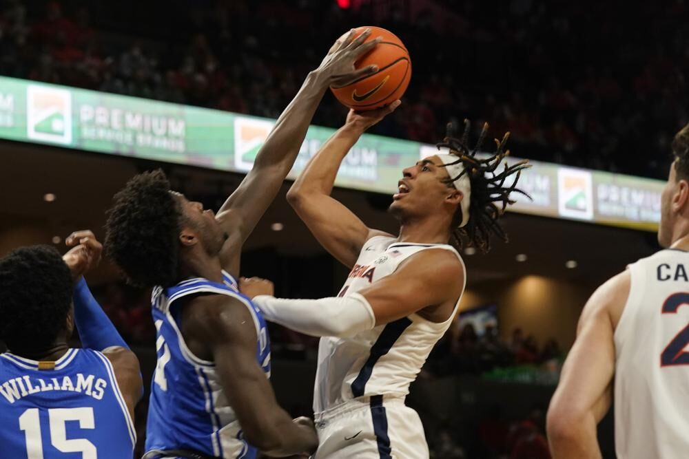 Duke forward Theo John (12) blocks the shot of Virginia guard Armaan Franklin (4) during the first half of an NCAA college basketball game Wednesday in Charlottesville, Va.