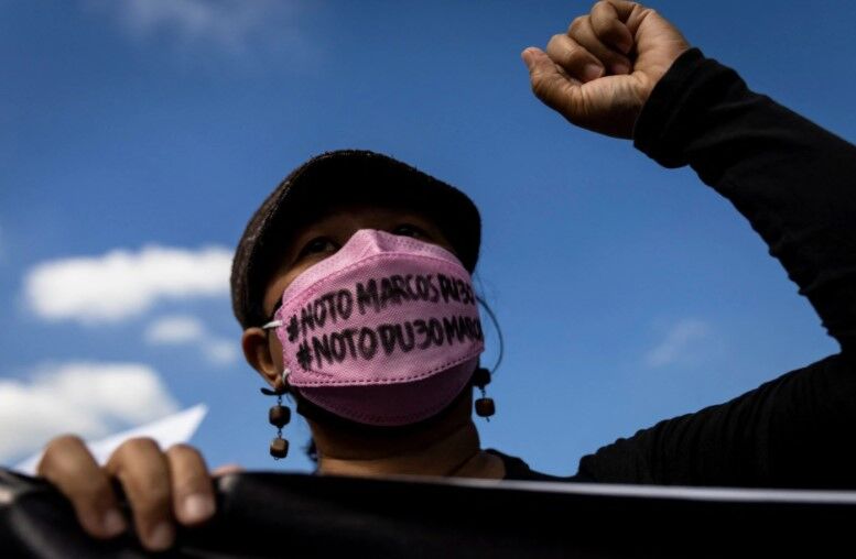 A woman raises her fist during a rally marking the anniversary of the 1986's People Power Revolution that overthrew the late dictator Ferdinand Marcos, near the EDSA People Power monument in Quezon City, Metro Manila, Feb. 25, 2022. 