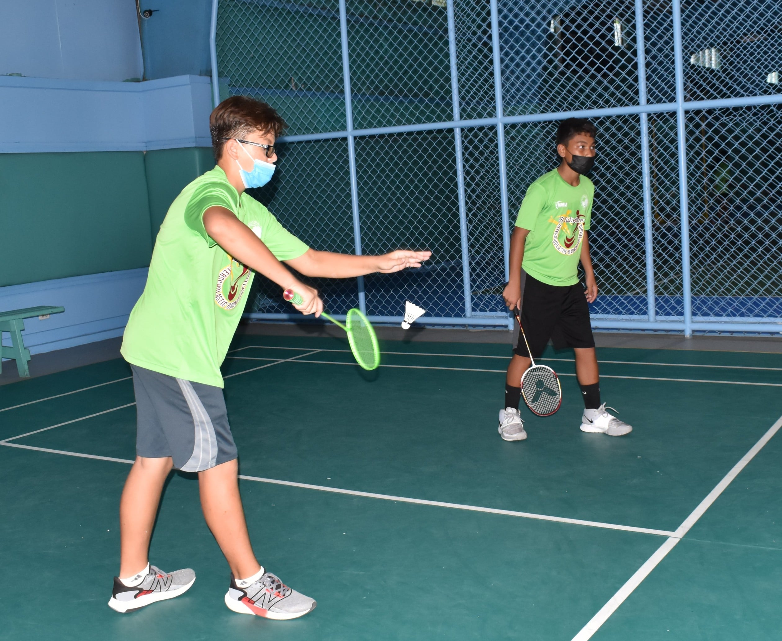 A Saipan International School player serves while his teammate looks on during a boys doubles game against Hopwood Middle School 2 in the opening week of the TakeCare Interscholastic Badminton League Saturday at the TSL Sports Complex