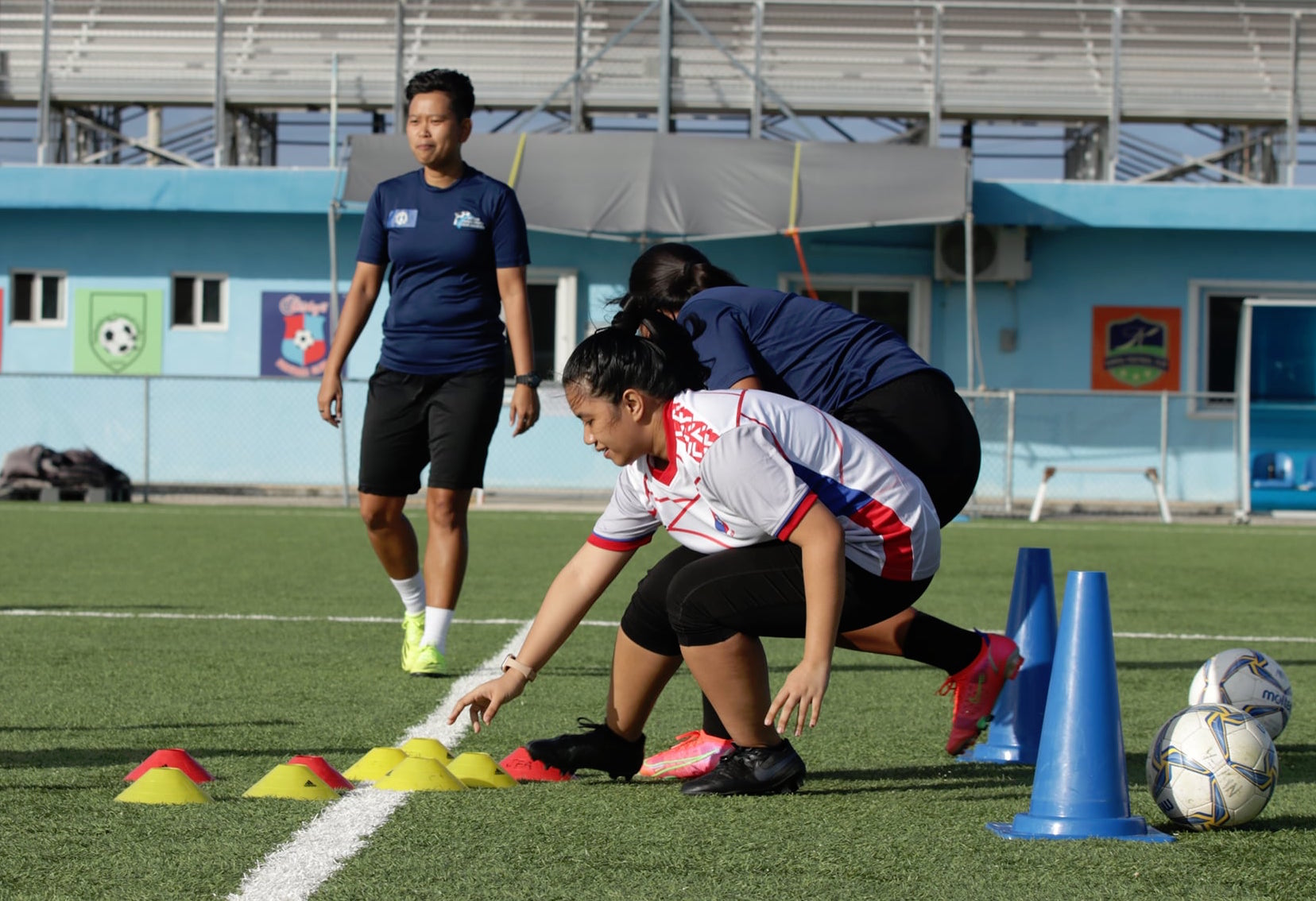 Participants in the Grassroots Kids Leader Coaching Course perform fun drills, while Northern Mariana Islands Football Association coach Mae Ito looks on during the practical session of the event Saturday at the NMI Soccer Training Center in Koblerville.
