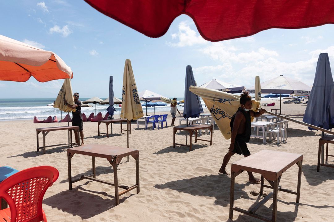 Workers pack up the parasols to close the beach as Indonesia imposes emergency measures, tightening restrictions in Java and Bali as coronavirus disease cases surge in Seminyak, Bali, Indonesia, July 3, 2021.