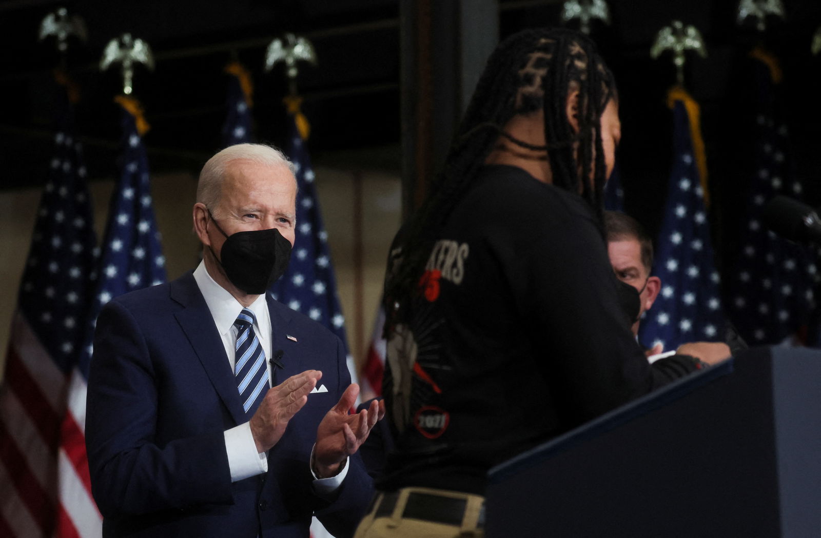 President Joe Biden applauds Cranita Jordan, a 4th year apprentice at Ironworkers Local 5, after she addressed the crowd gathered to see the president sign an executive order on federal construction project contracts and labor agreements during a visit to Ironworkers Local 5 in Upper Marlboro, Maryland, February 4, 2022.