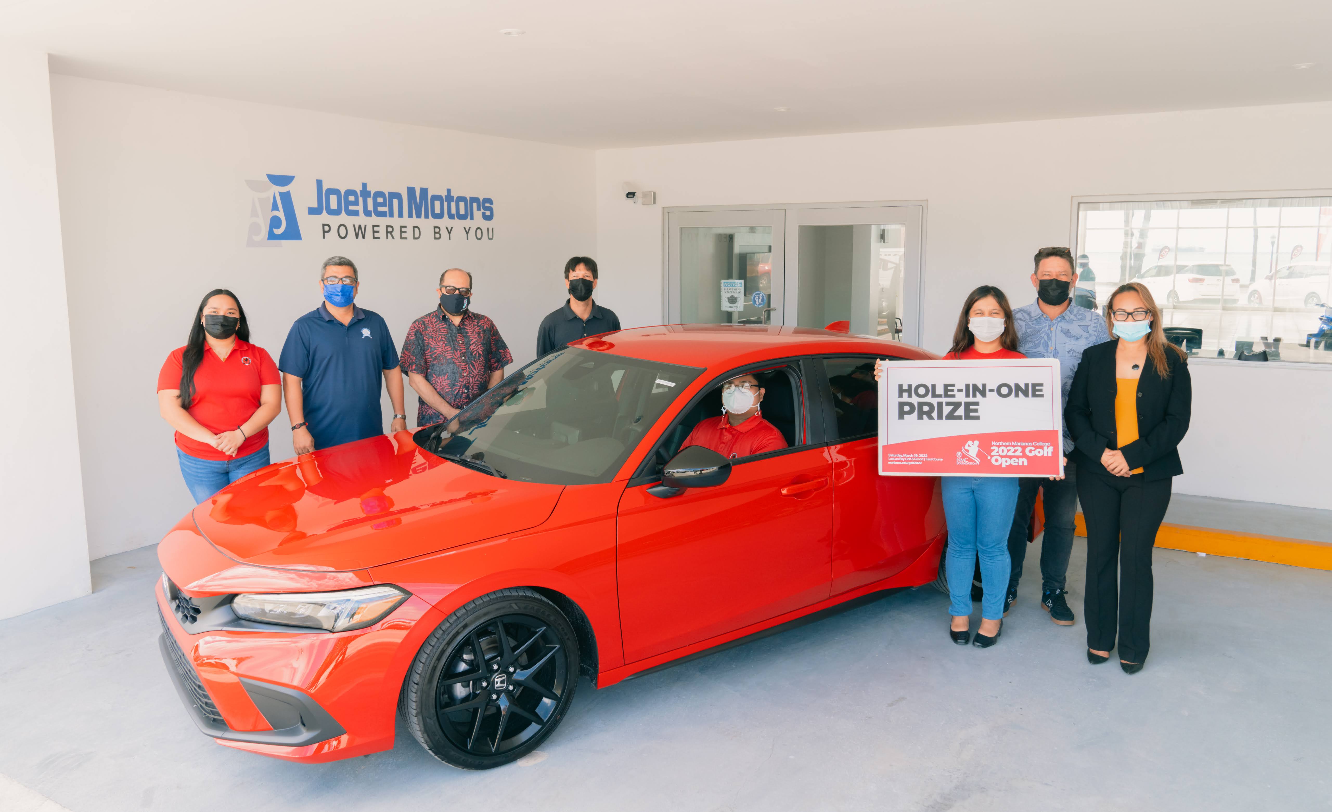 Joeten Motors is offering a brand new 2022 Honda Civic Sport Hatchback as a hole-in-one prize in the upcoming 17th Annual NMC Foundation Golf Tournament. In this photo are NMC students and employees along with NMC President Galvin Deleon Guerrero, EdD and Joeten Motors representatives Matthew Deets, Boss Alvarez, and Peter Tenorio.