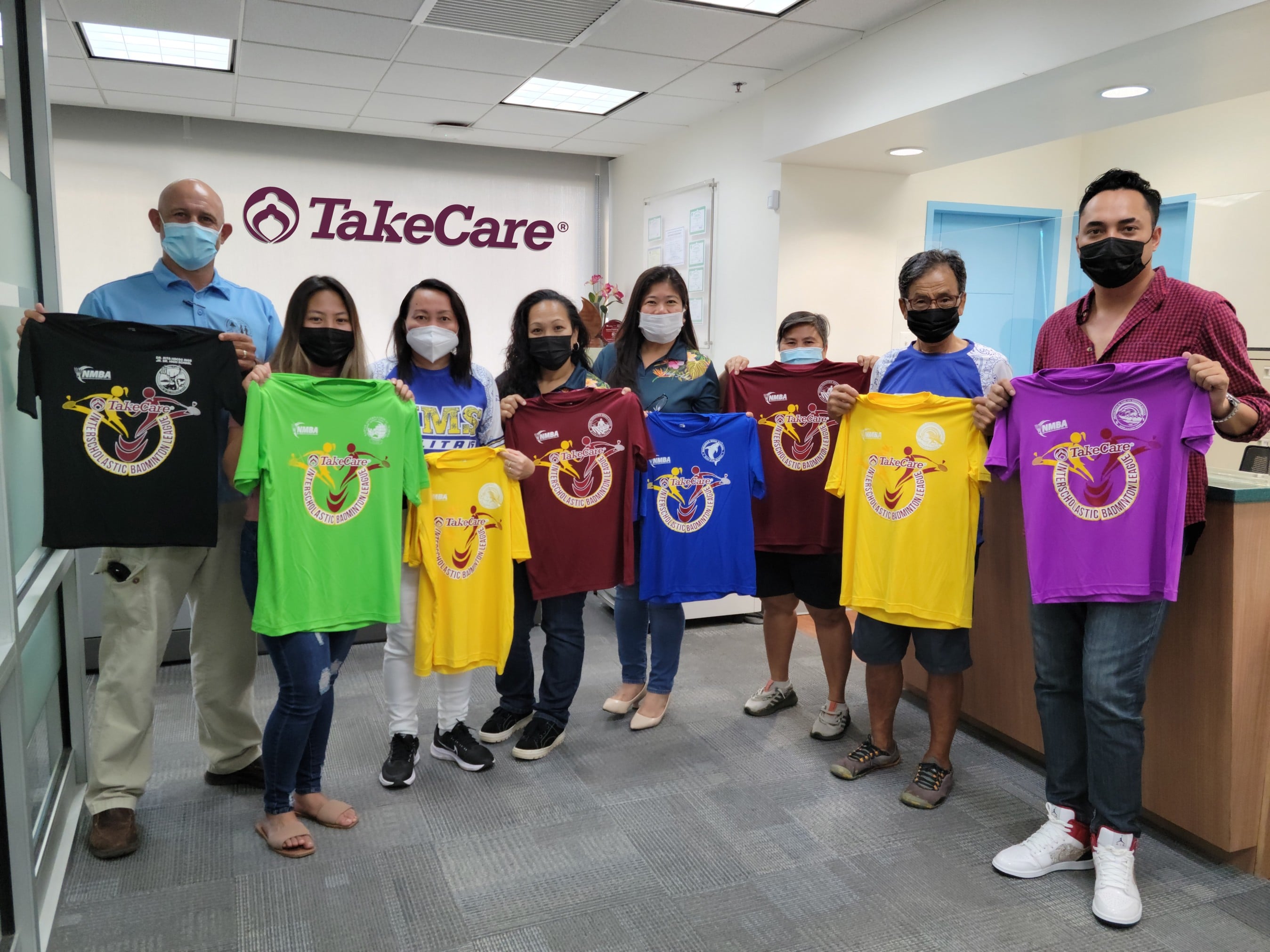 Public School System Athletics Program Director Nick Gross, left, poses for a photo with middle school coaches and Northern Marianas Badminton Association officials after receiving the uniforms for the inaugural season of the TakeCare Interscholastic Badminton League from TakeCare Insurance Company Inc. representatives Friday at the TSL Plaza in Garapan.
